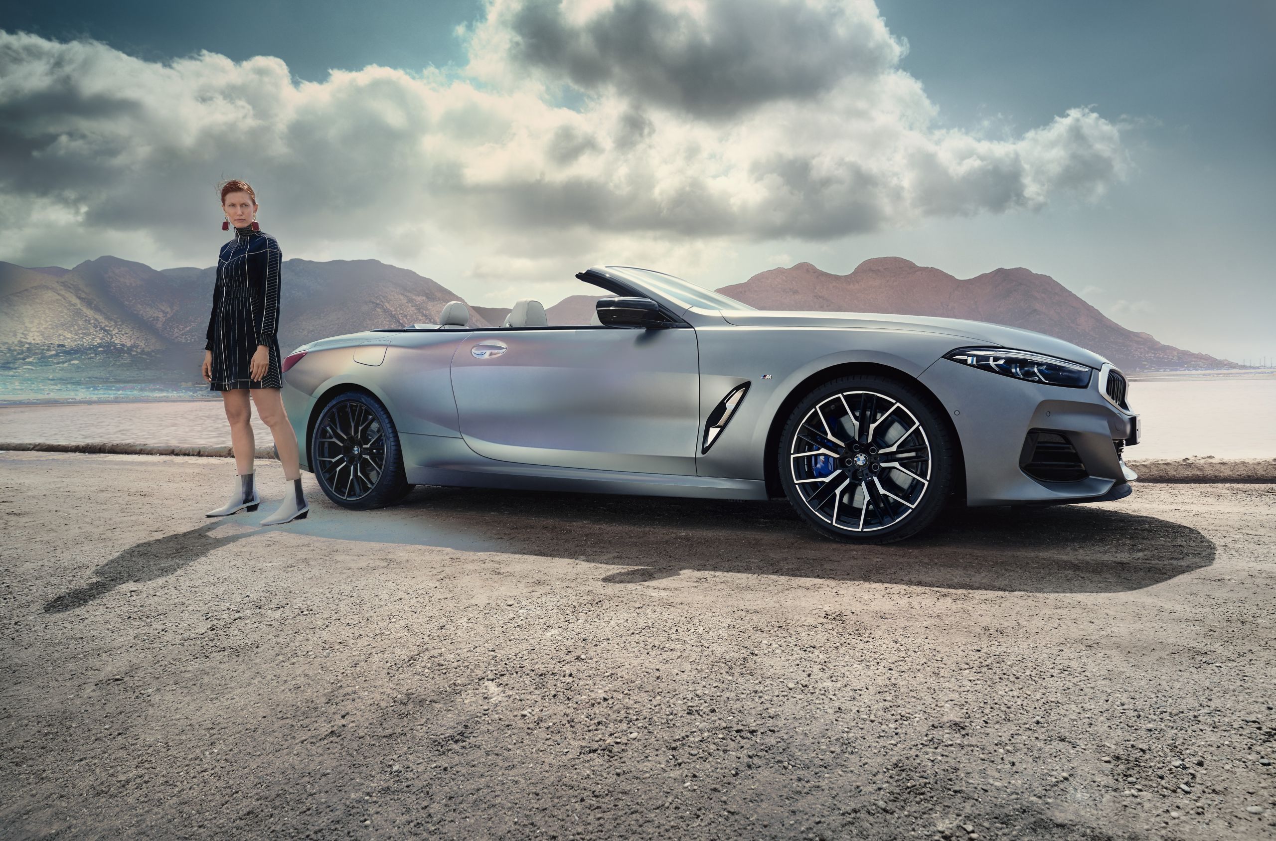 Girl standing near BMW in desert