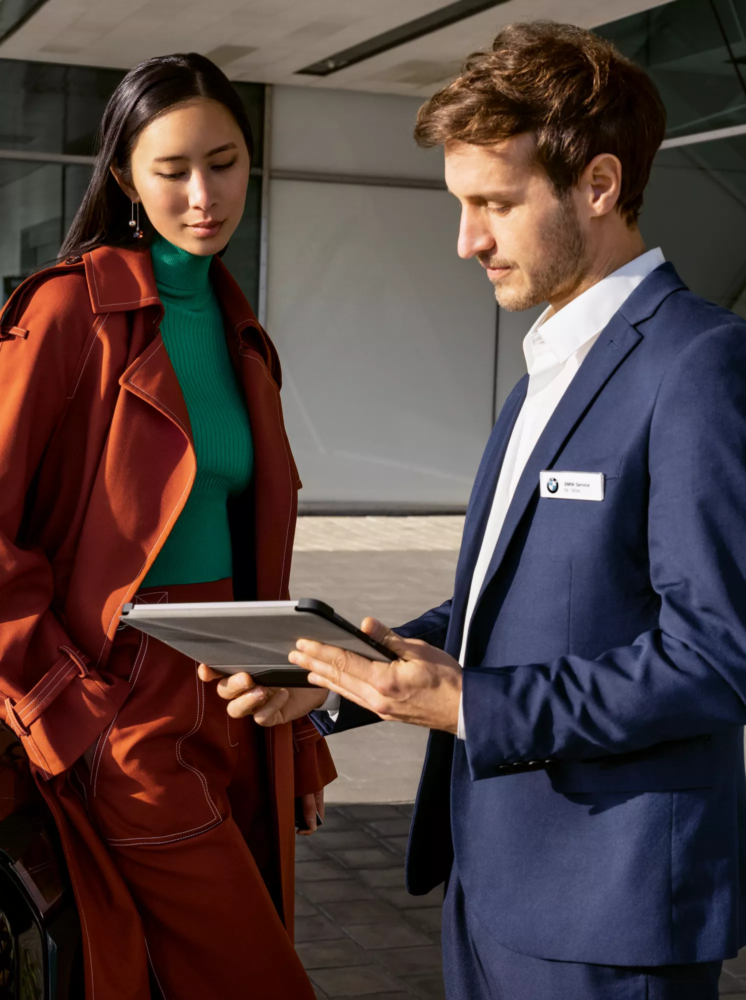 Mulher a falar com um especialista ao lado de um BMW.