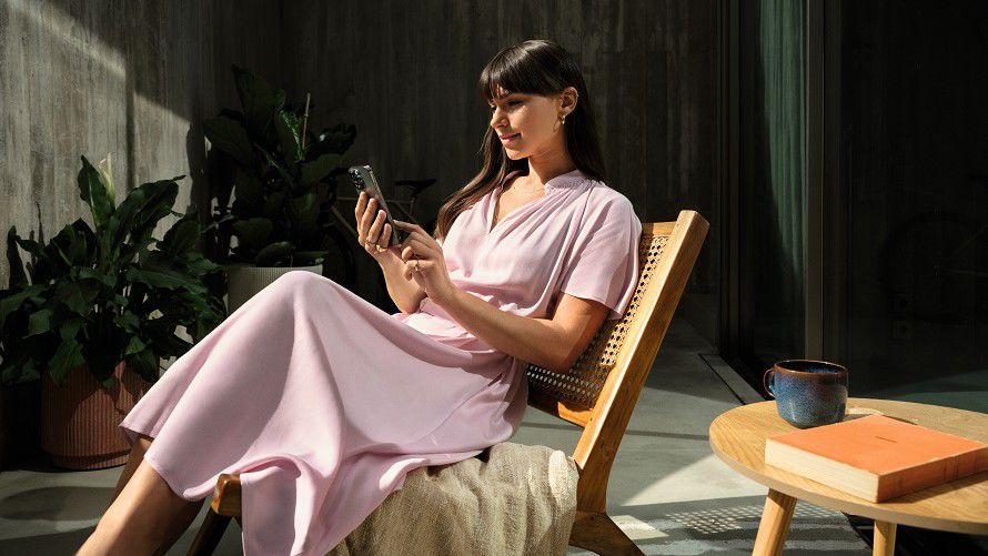 Una persona con un smartphone en la mano sentada en una silla