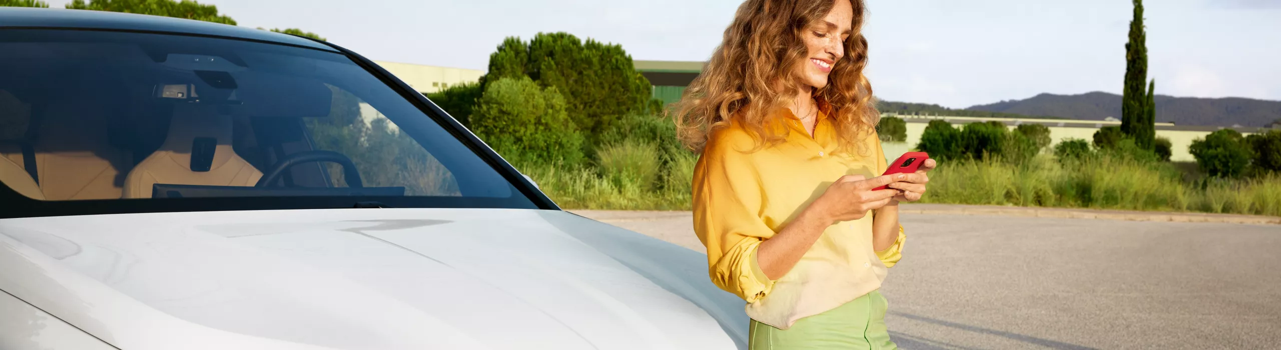 Mulher fazendo login no BMW Portal, junto de um BMW iX