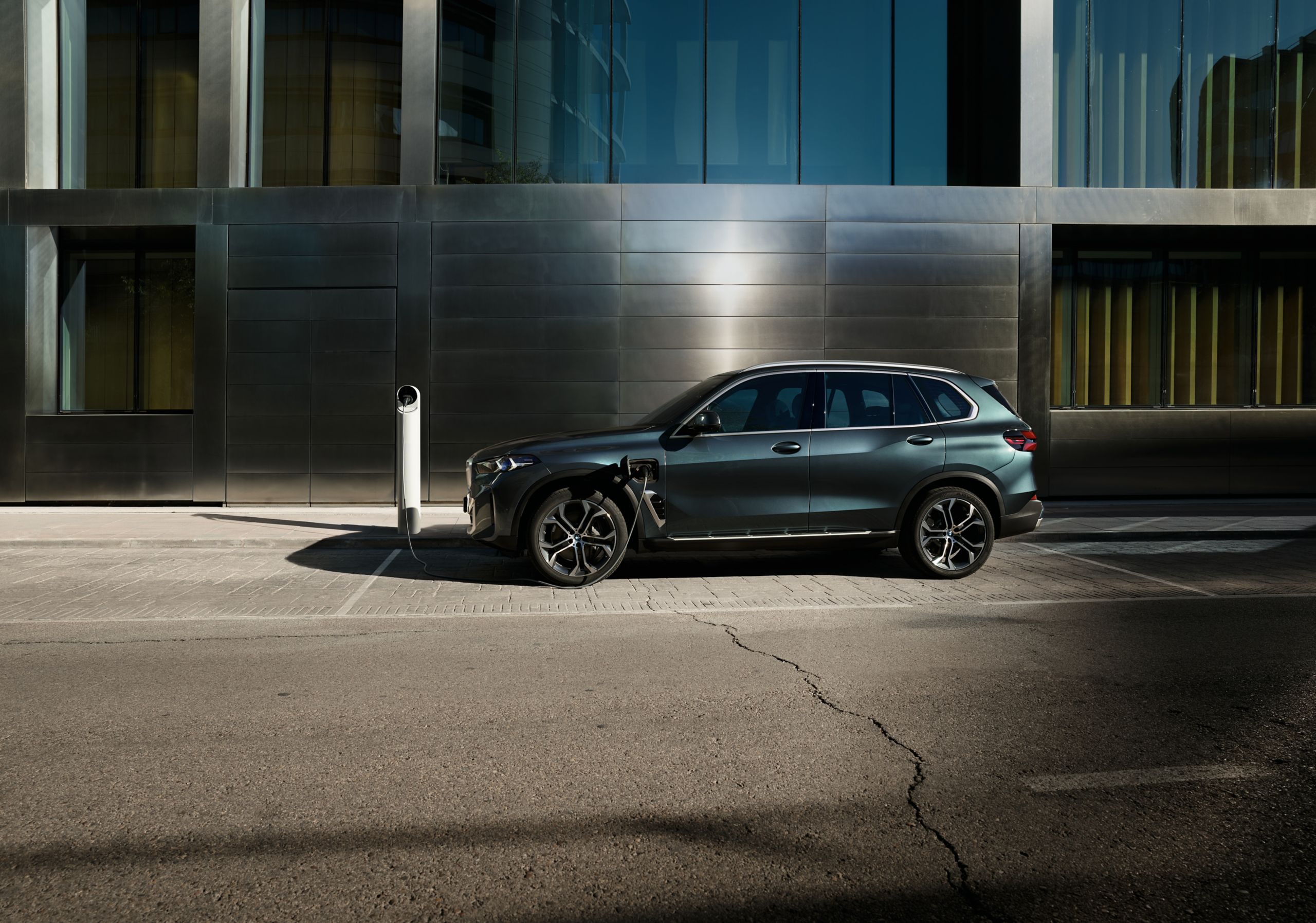 Deux voitures BMW roulent côte à côte sur une route sinueuse abstraite