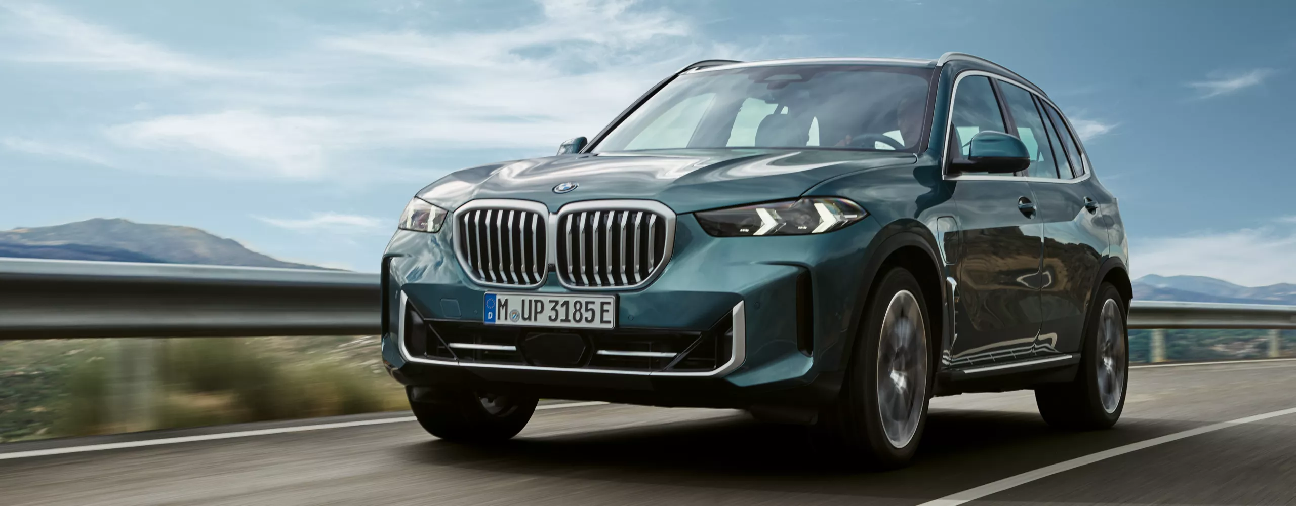  Een BMW X3 plug-in hybride staat in de zon in een bergachtige rotswoestijn
