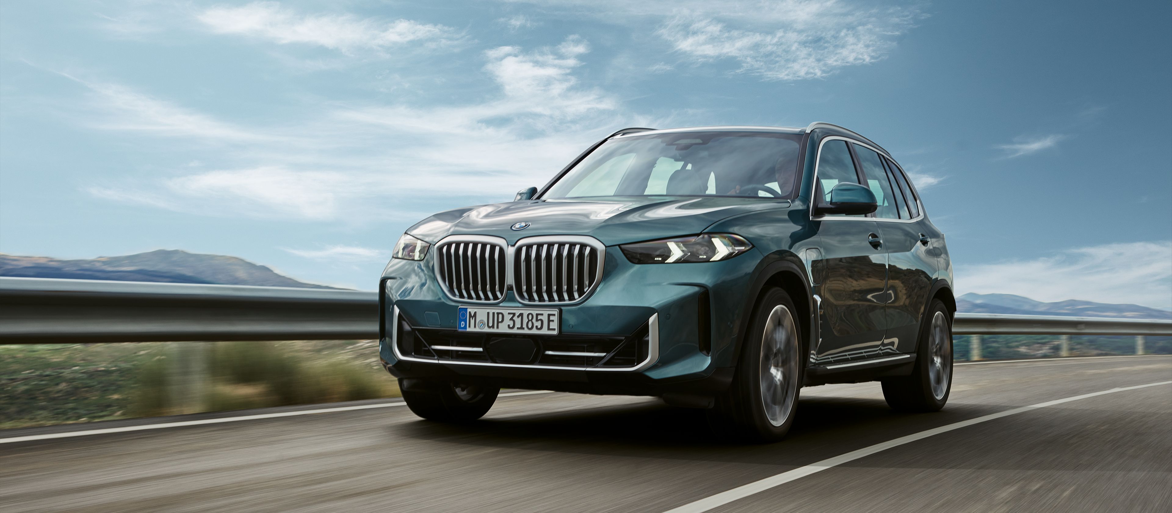  Een BMW X3 plug-in hybride staat in de zon in een bergachtige rotswoestijn
