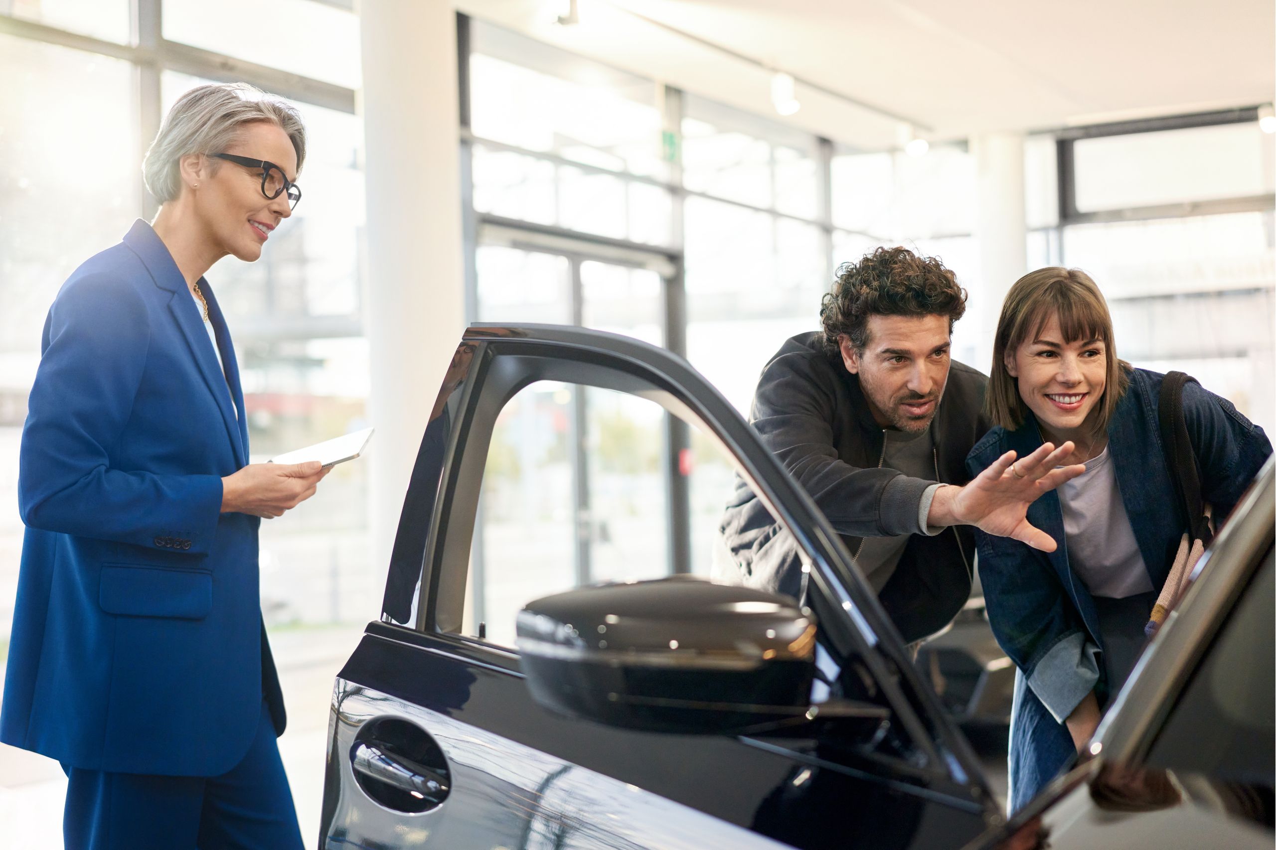 A BMW saleswoman accompanying a couple through the BMW purchasing experience.