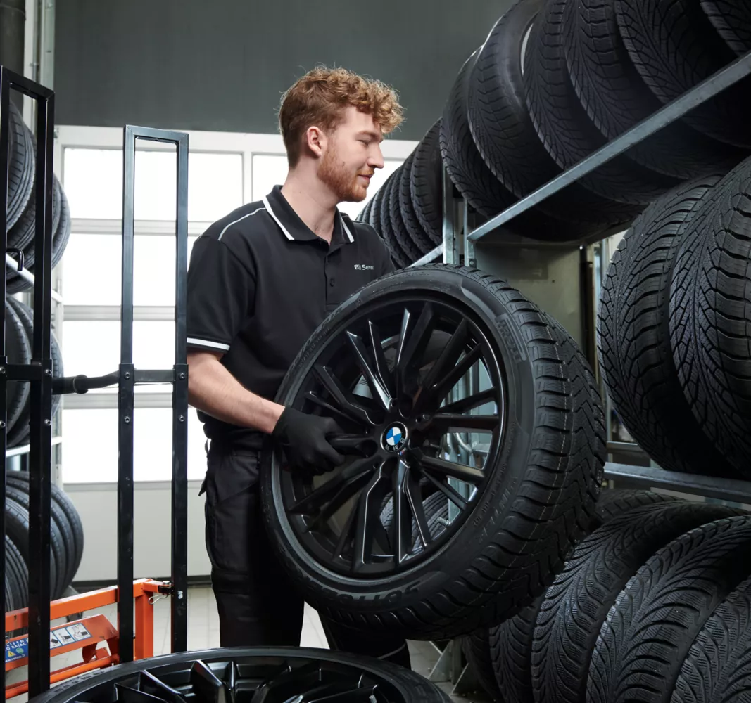 Ein Mann lagert einen Reifen ein. 