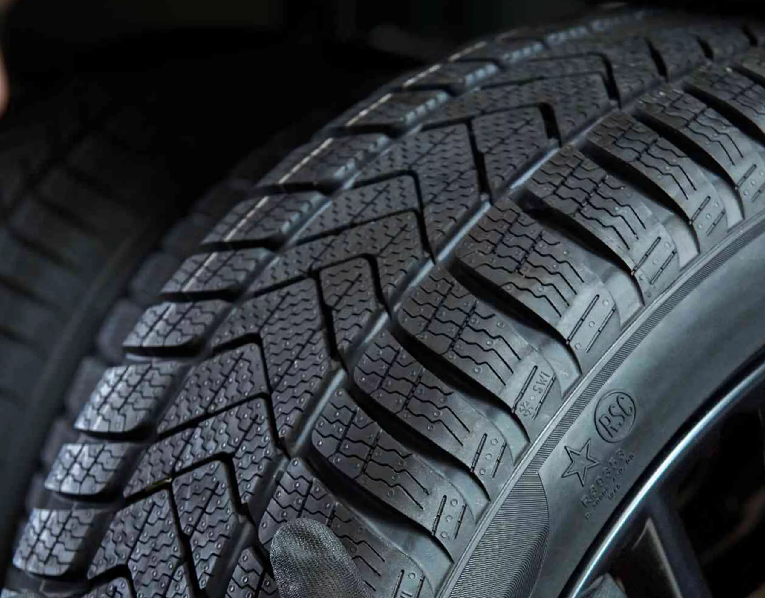 Un groupe de personnes avec des sacs à dos et des casques s’avance vers un mur d’escalade. Une BMW est garée à côté