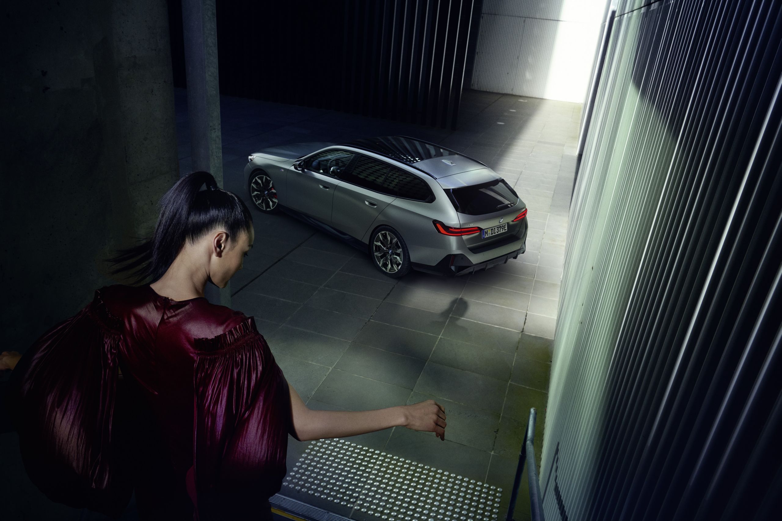Girl going down the stairs to a parked BMW Touring
