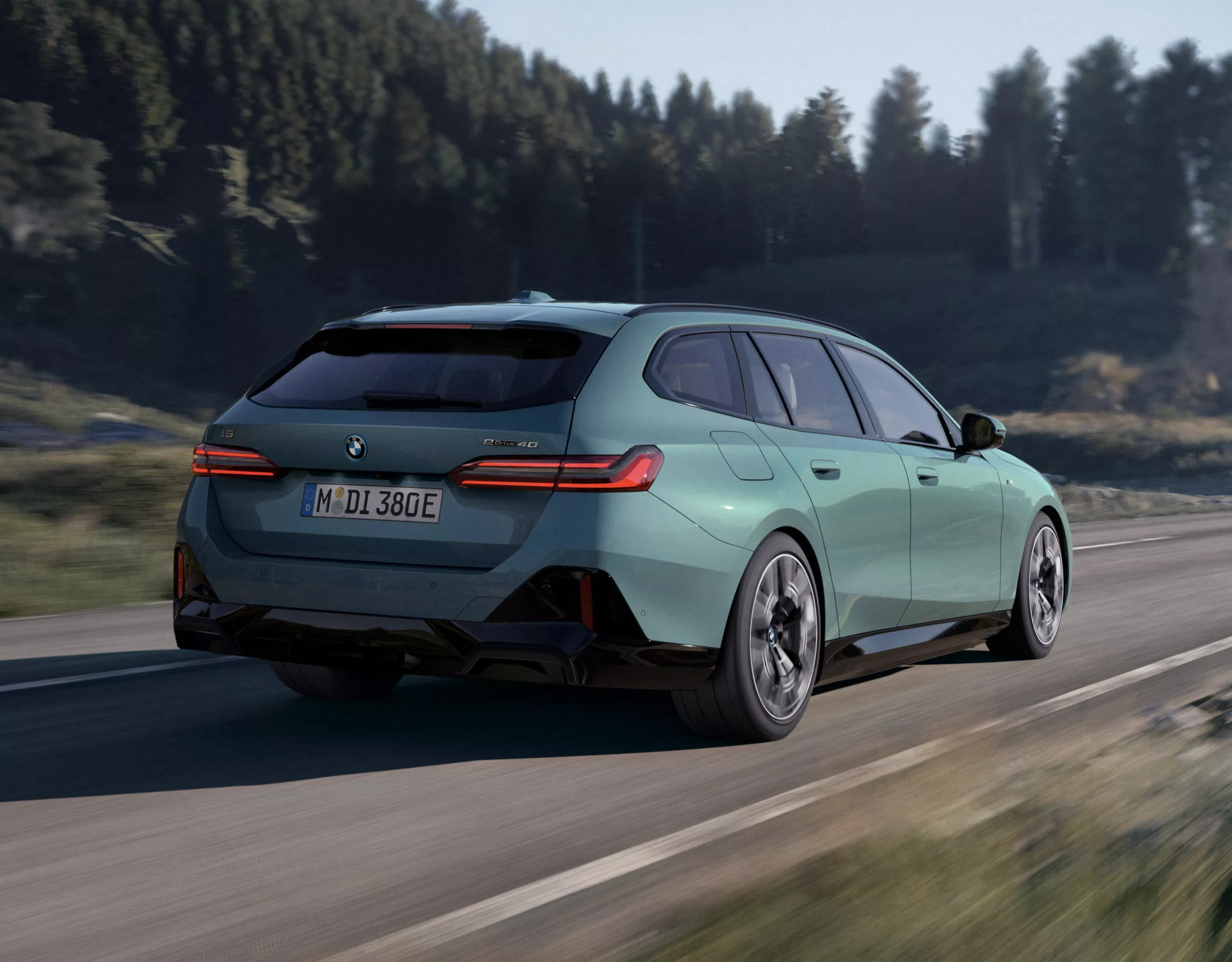 BMW i5 M60 xDrive純電性能房車，Fire Red Metallic銀粉漆，停駛在陽光明媚的停車場屋頂上