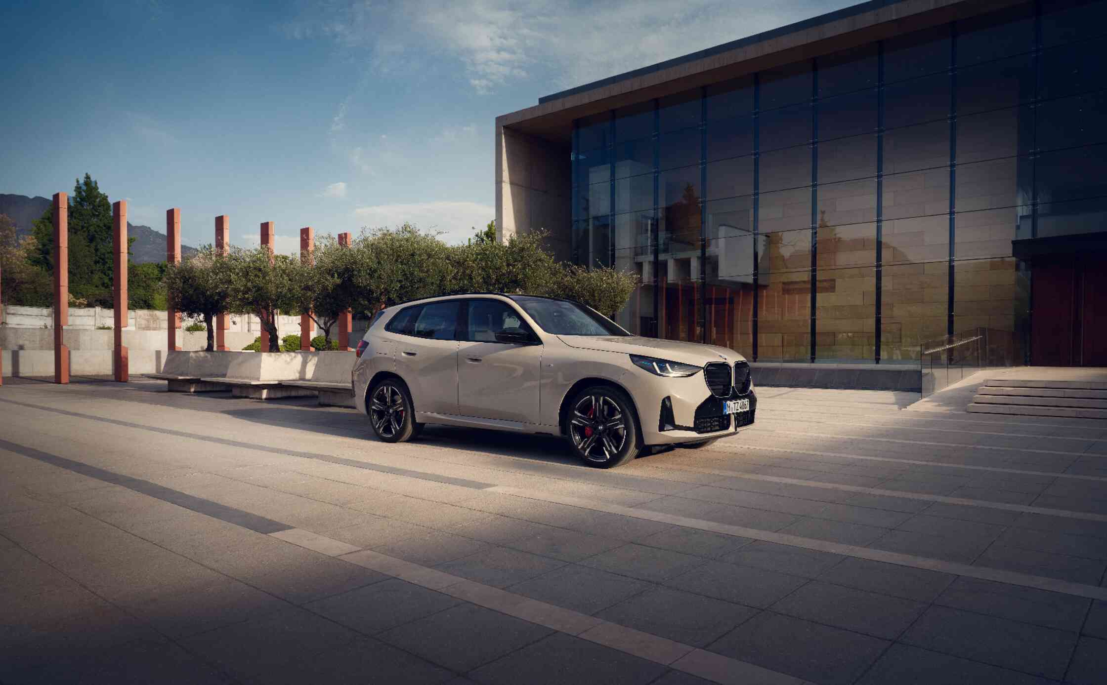 Ein BMW X3 steht vor einem modernen Gebäude mit Glasfassade