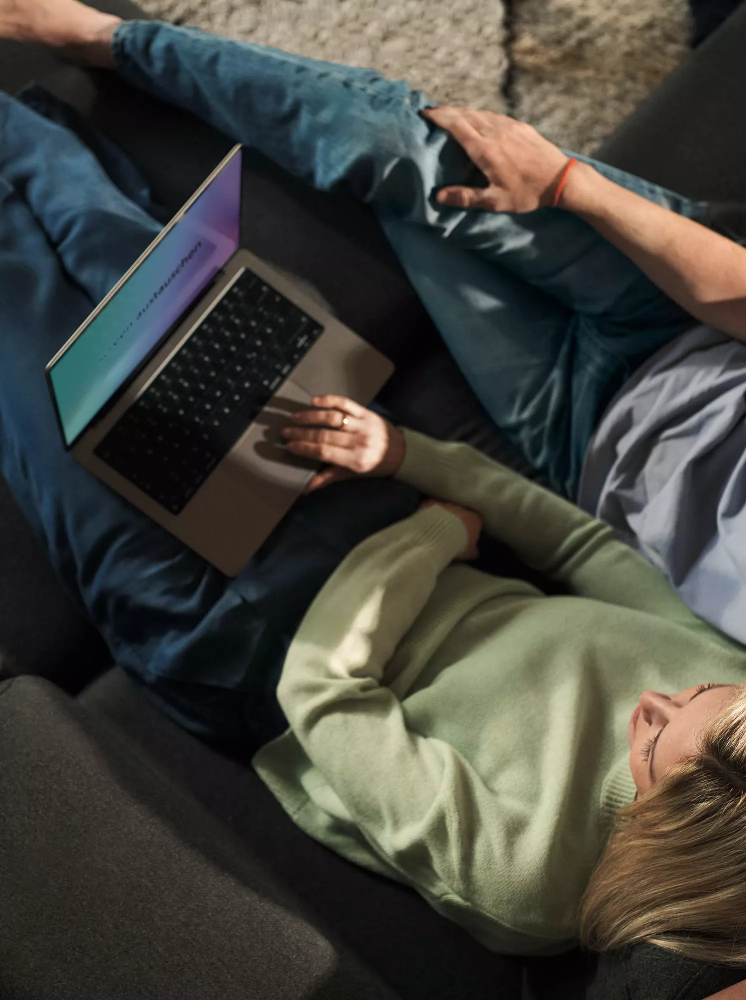 Girlfriend and boyfriend looking at laptop on couch. 