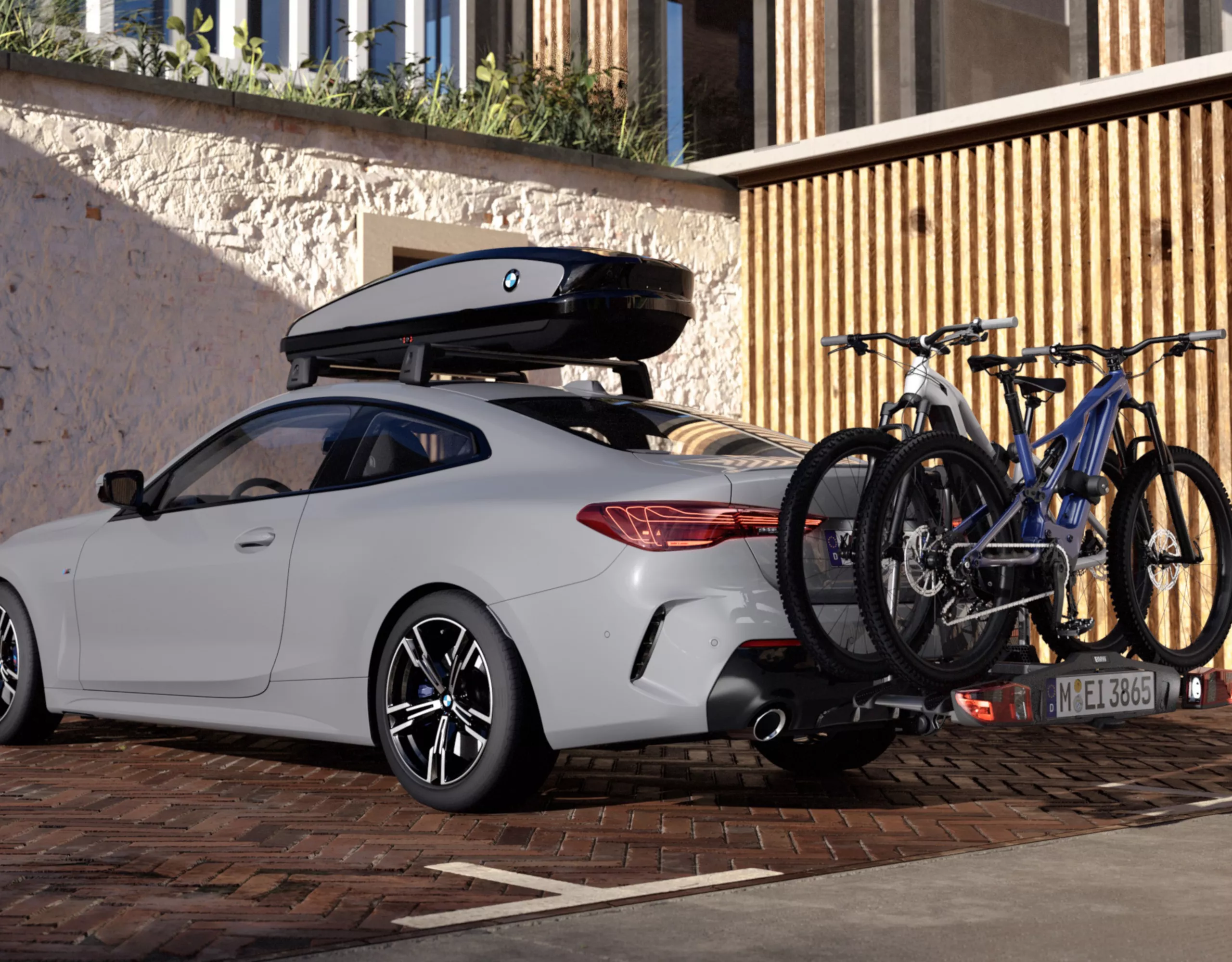 Ein Dachgepäckträger von BMW, montiert auf einem grauen BMW mit zwei Fahrrädern auf einem Fahrradheckträger.