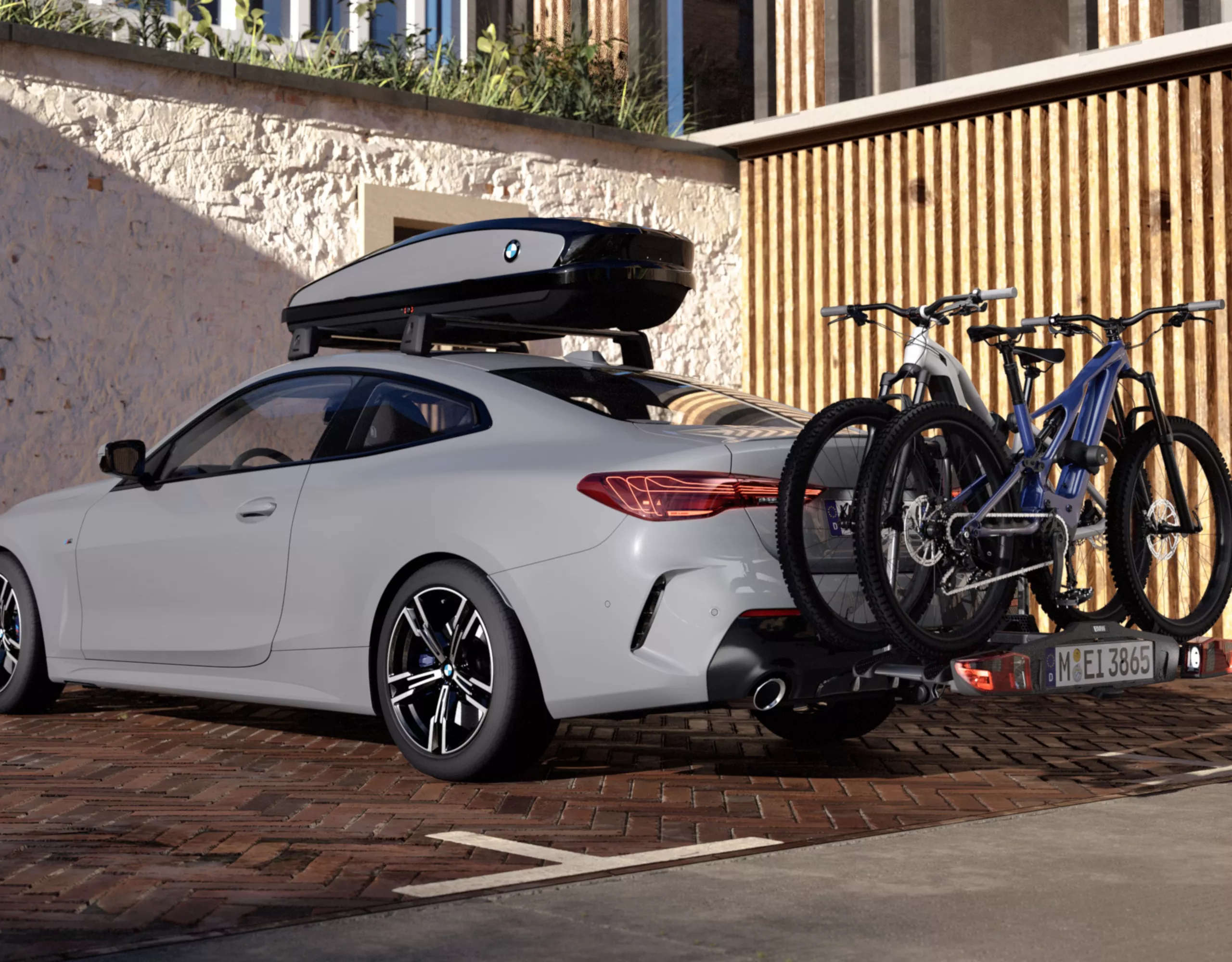 Ein Dachgepäckträger von BMW, montiert auf einem grauen BMW mit zwei Fahrrädern auf einem Fahrradheckträger.