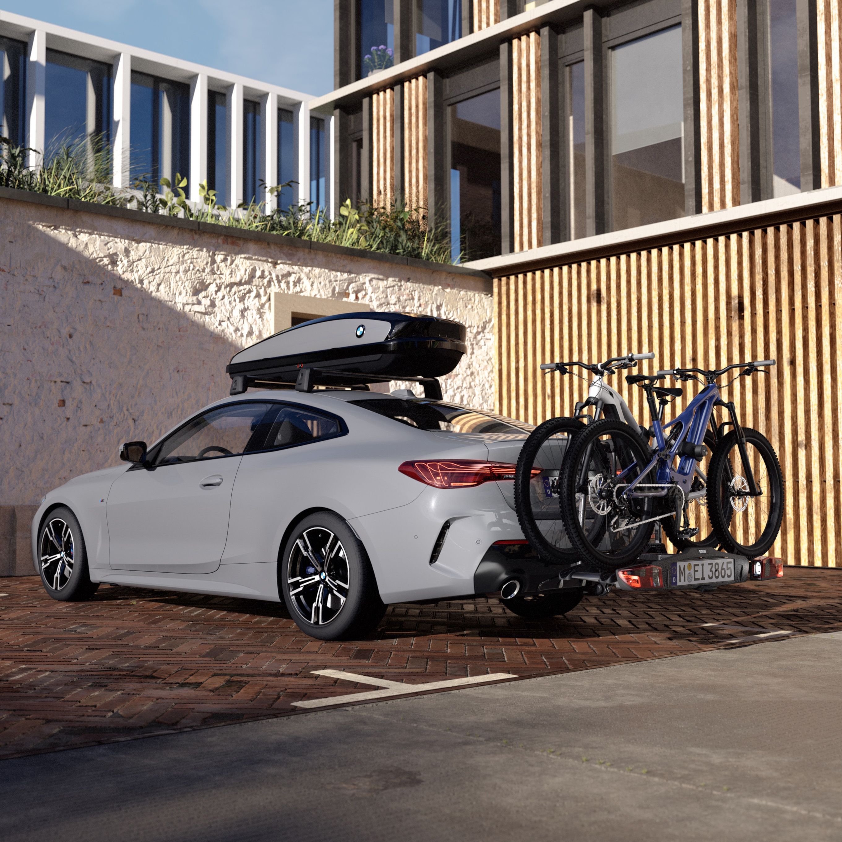 Une galerie de toit BMW montée sur une BMW grise avec deux vélos sur un porte-vélos arrière.