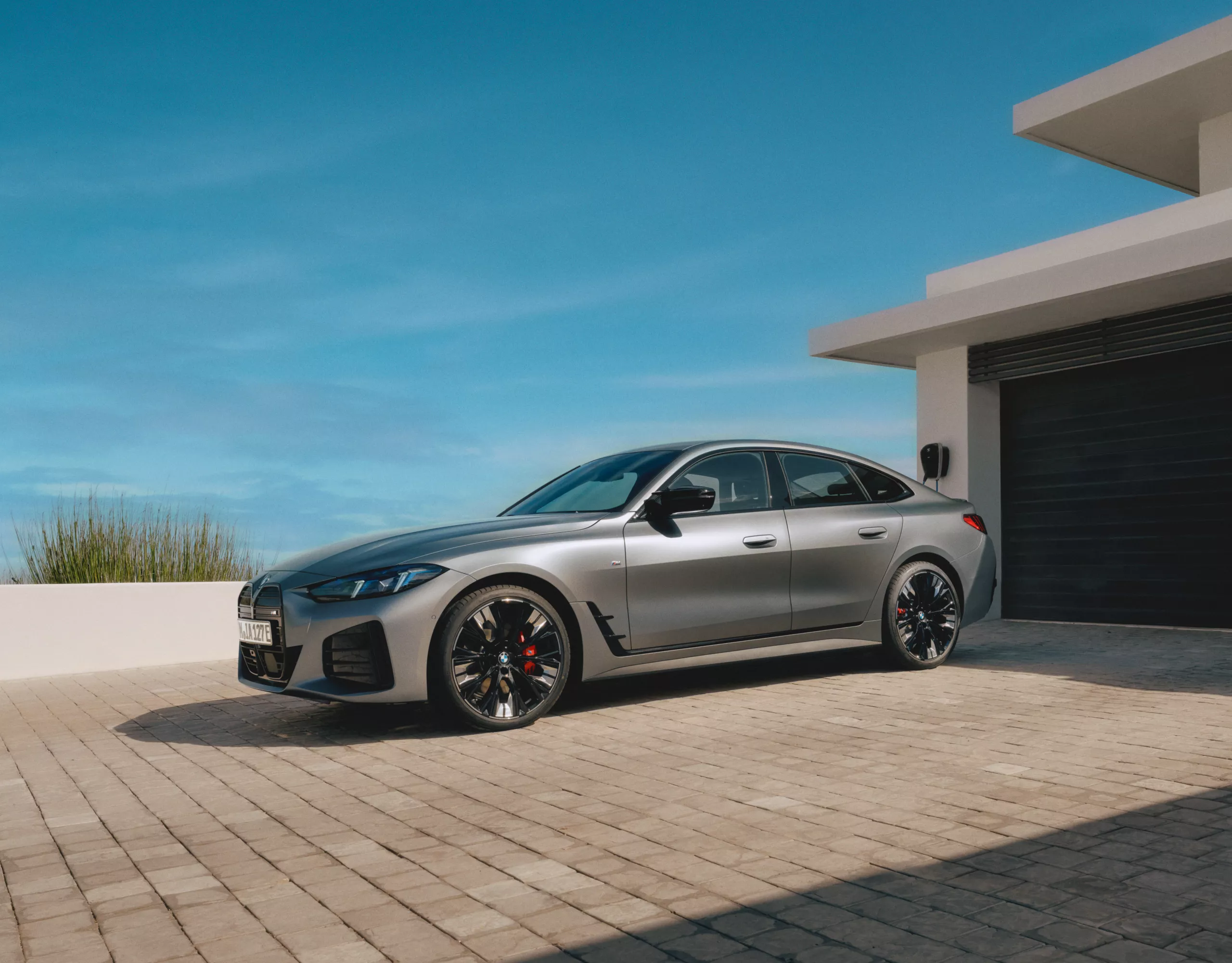 Modern silver sports sedan outside luxury home