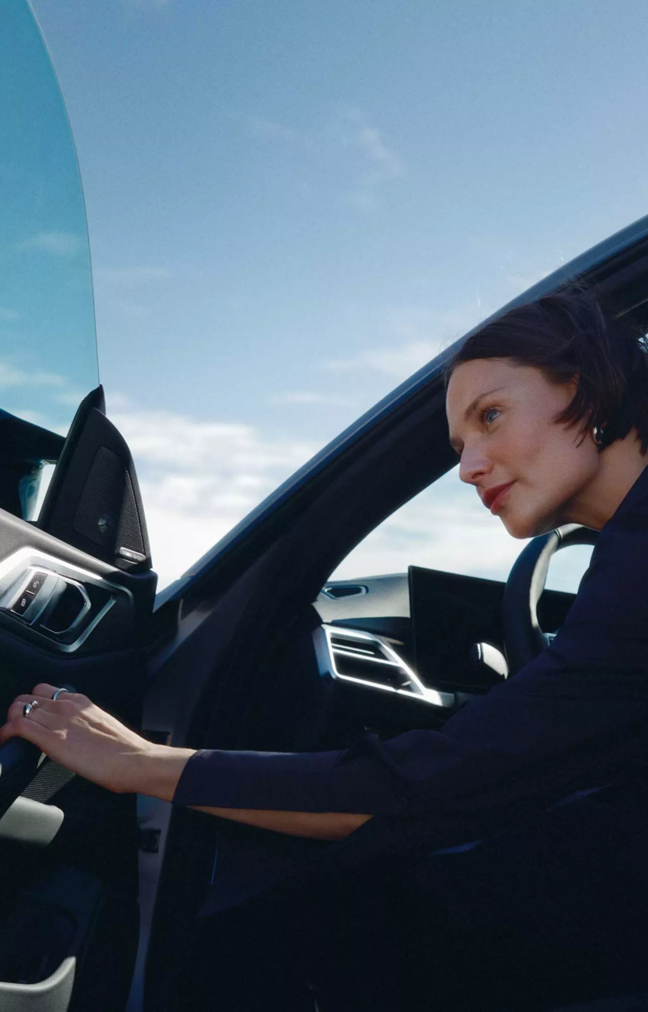 Une conductrice monte à bord de sa BMW électrique