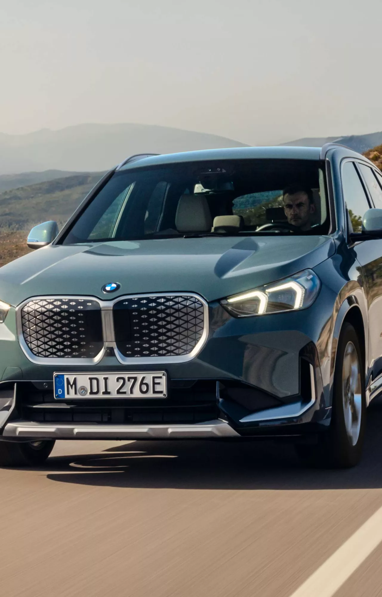 Une BMW iX1 sur une route de montagne