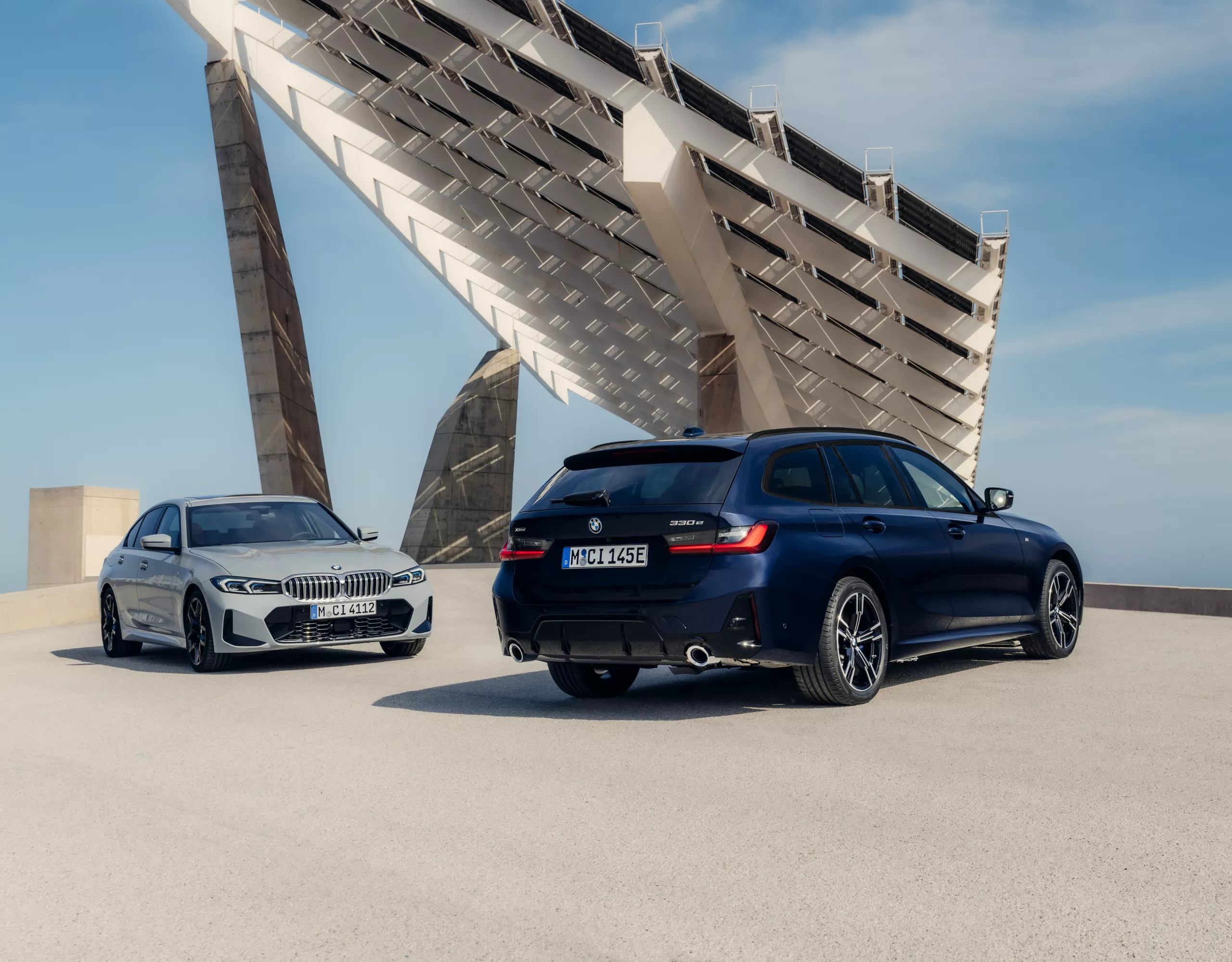 Person geht zu blauem BMW vor BMW Service Gebäude in moderner urbaner Umgebung mit klarer Architektur