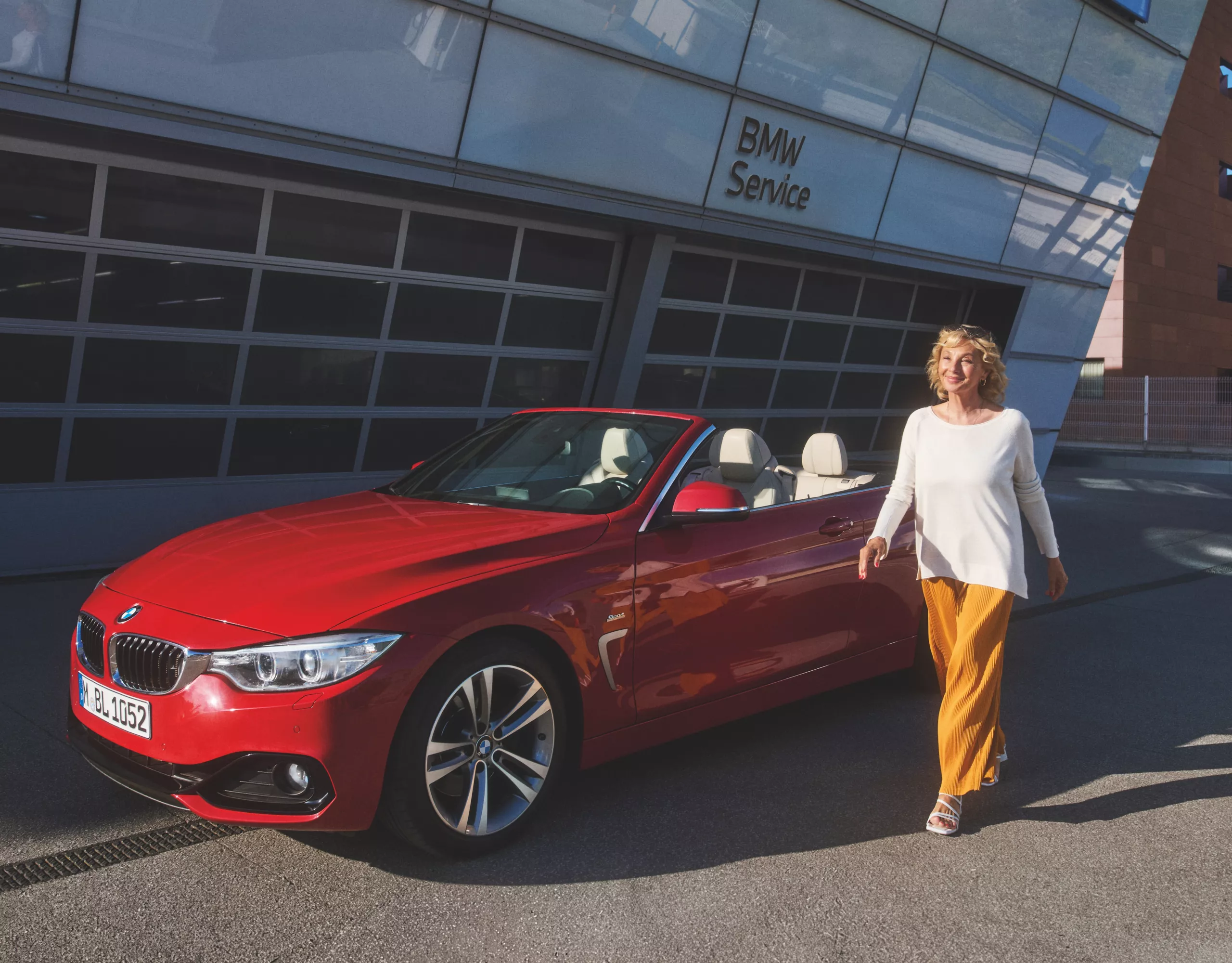 BMW Value Service BMW steht vor Garage mit Models
