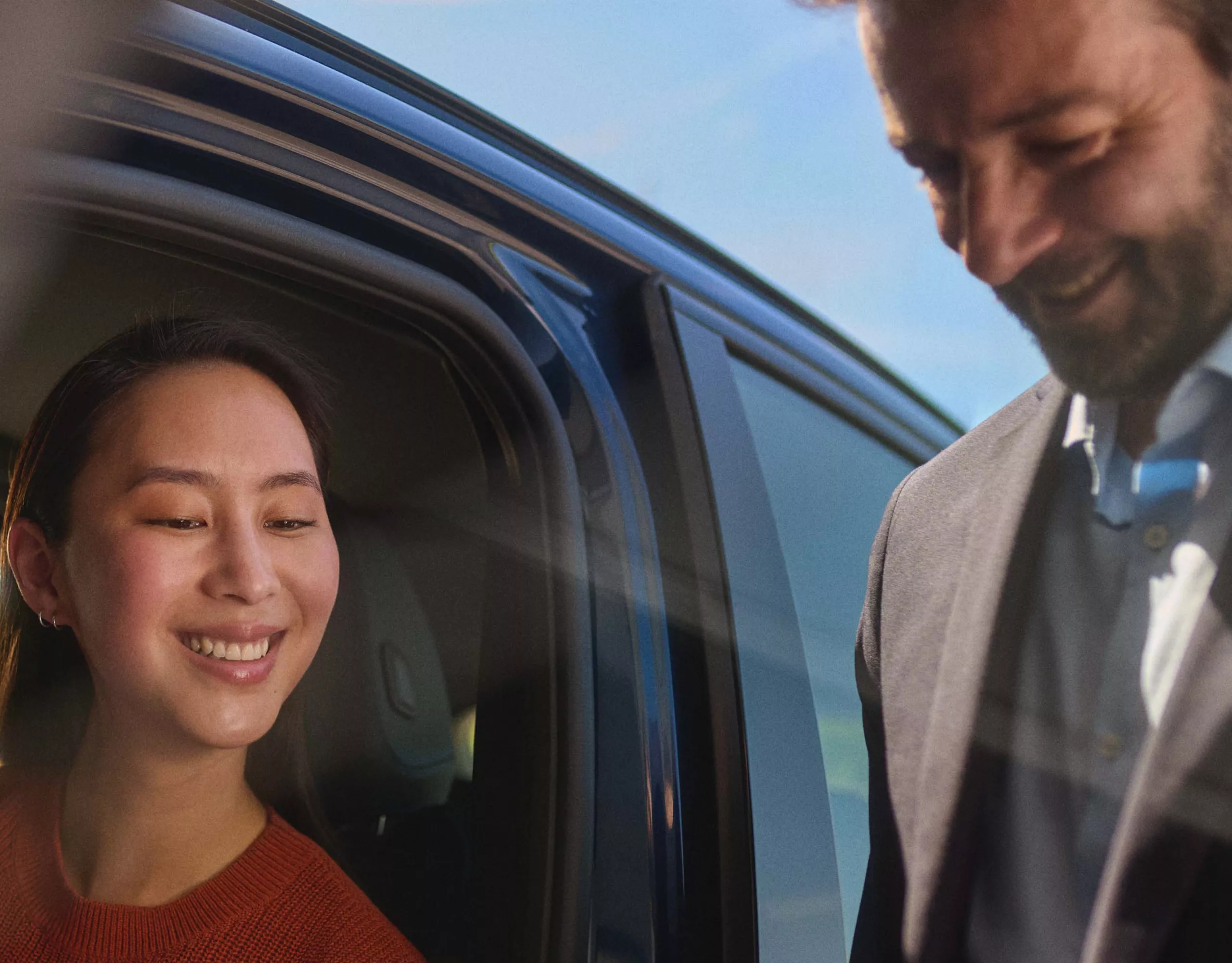 Zwei Personen stehen neben einem BMW Fahrzeug.