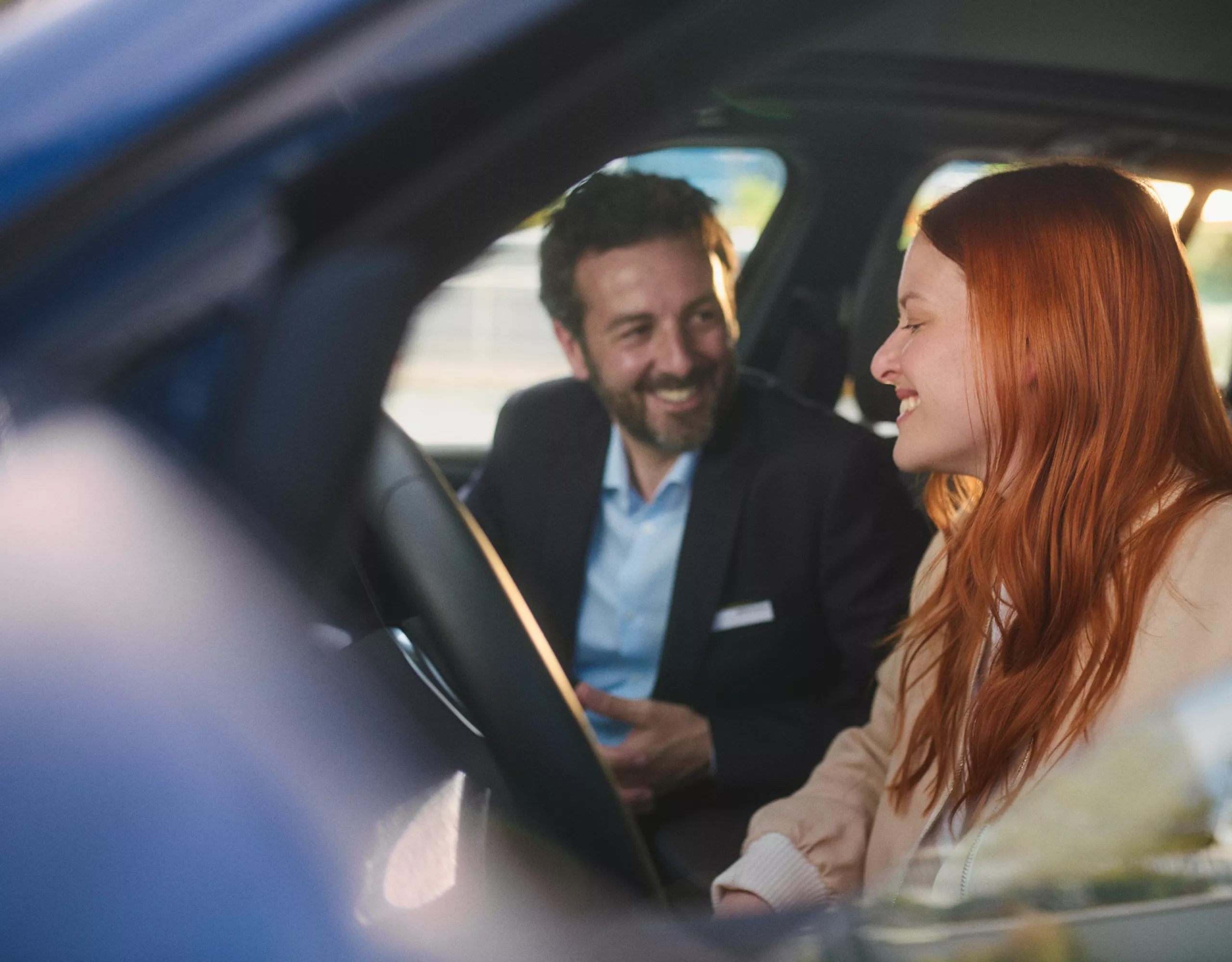 BMW Service Inclusive, egy férfi és egy nő támaszkodik egy tengerparton álló BMW i4-hez