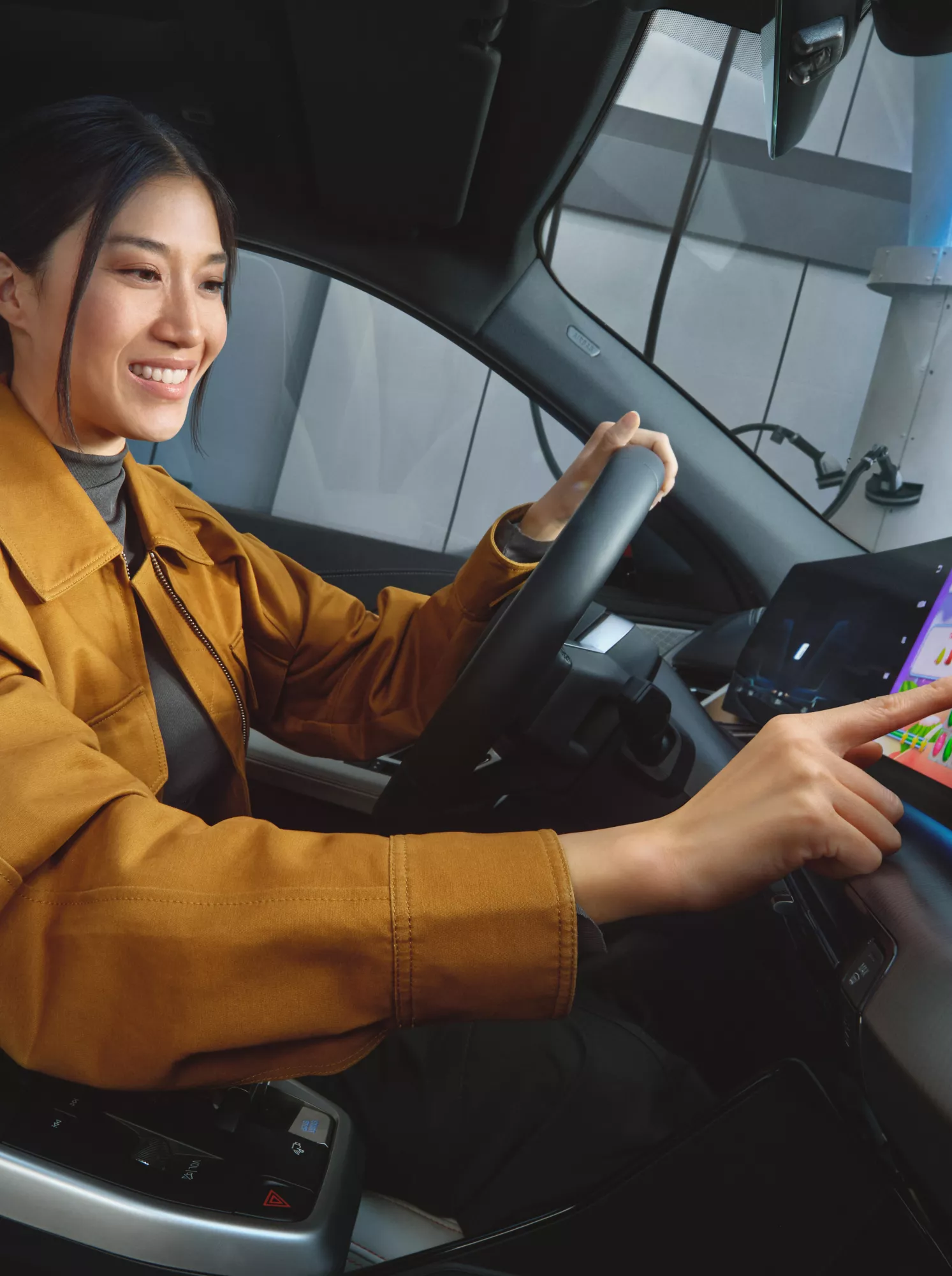 二人がスマートフォンとセンター・ディスプレイを使ってBMWでビデオゲームをしている