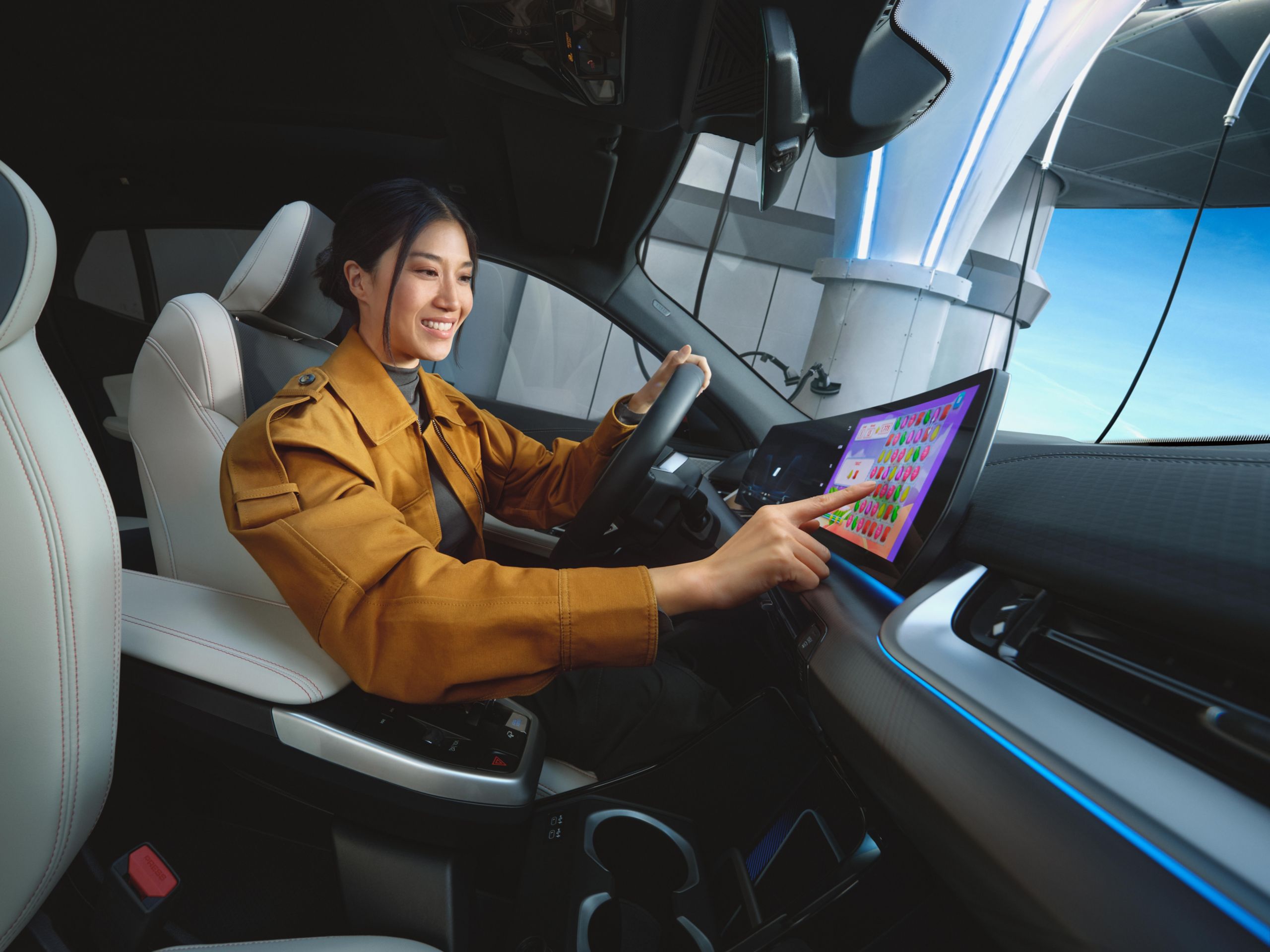 二人がスマートフォンとセンター・ディスプレイを使ってBMWでビデオゲームをしている