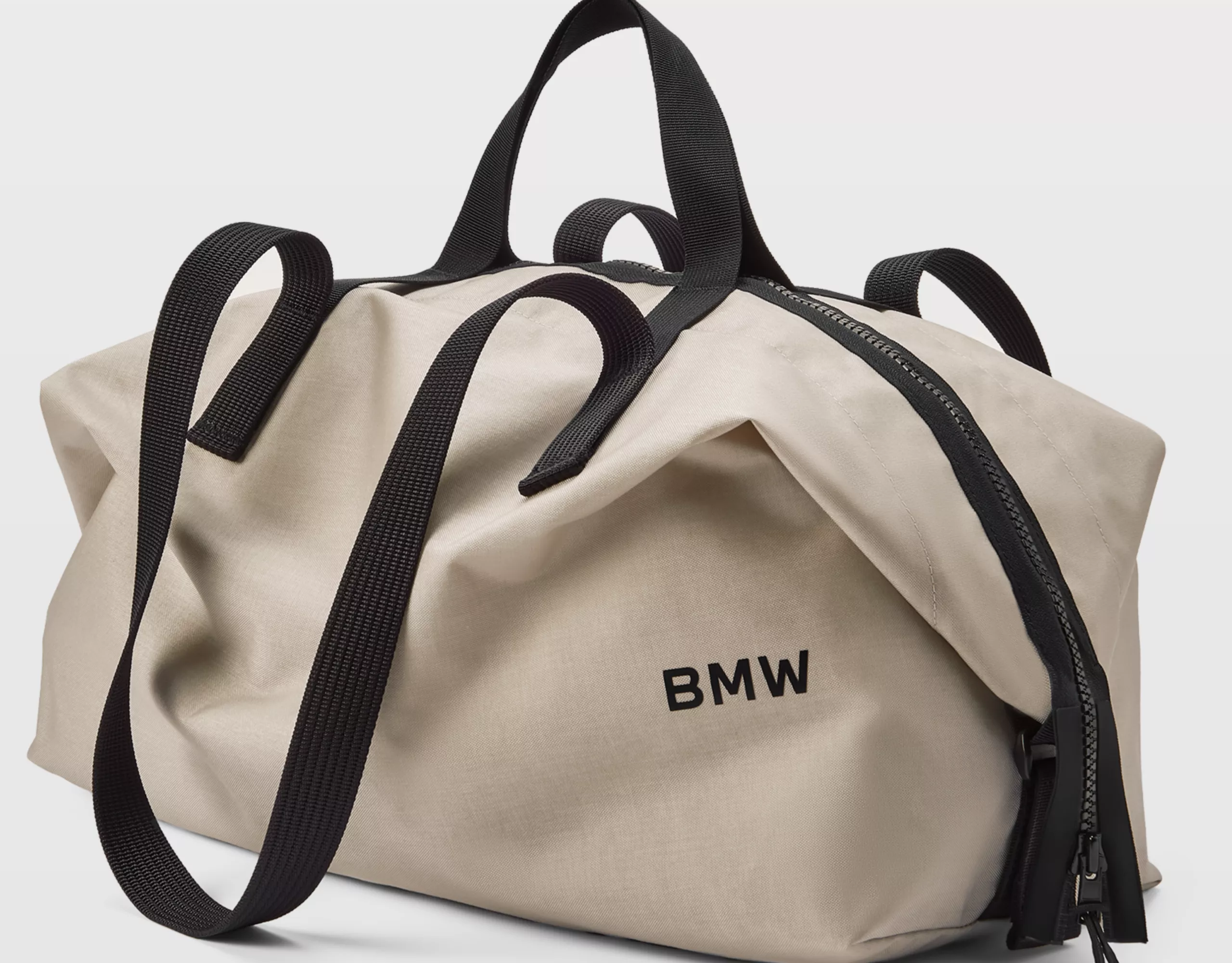 Les parfums BMW Lifestyle Amberness et Bergamood photographiés dans un paysage devant deux voitures BMW