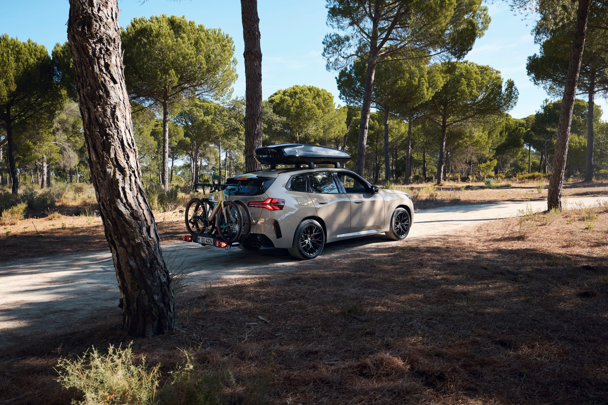 BMW X3 M50 xDrive equipado com suporte para bicicletas e caixa de tejadilho estacionado no meio da natureza