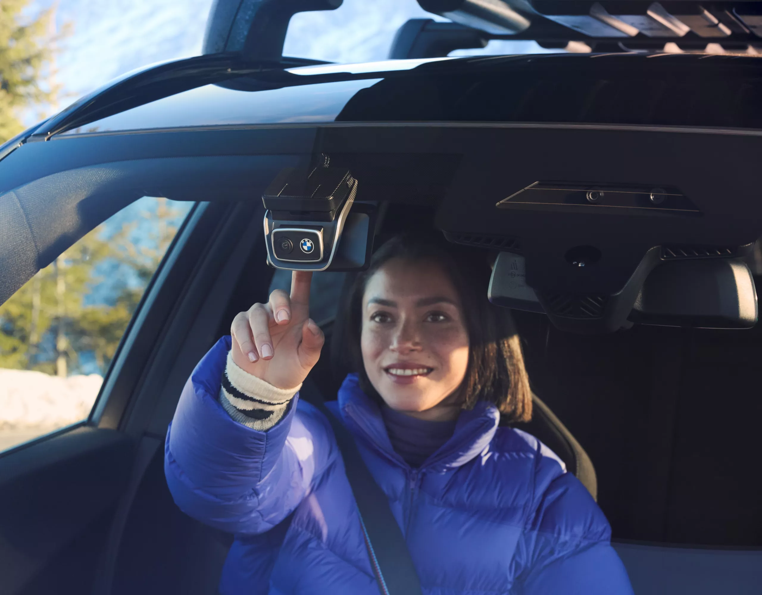 Une personne ouvre le coffre arrière sur un parking
