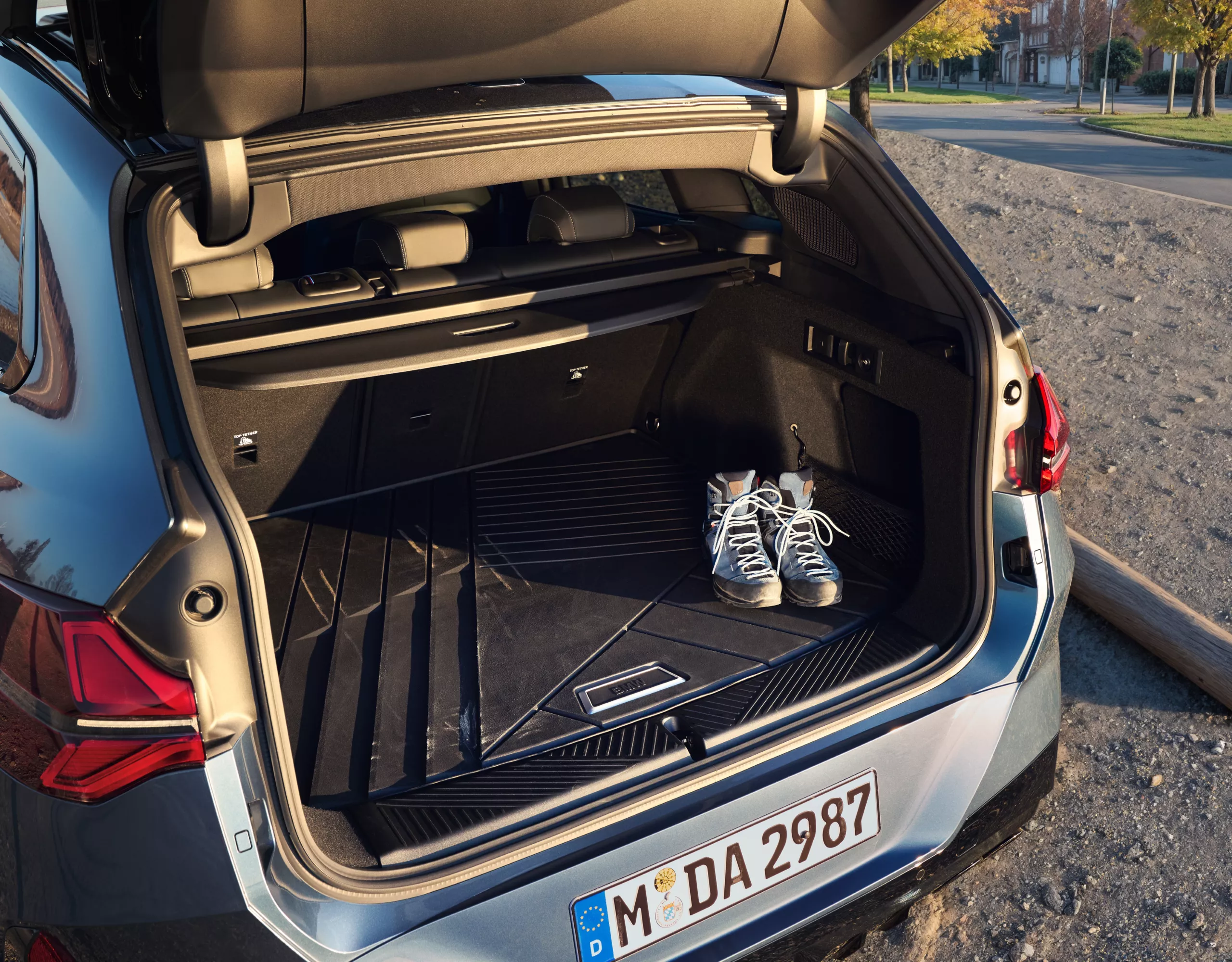 Une BMW équipée de chaînes neige est stationnée sur une route enneigée – vue détaillée de la roue arrière
