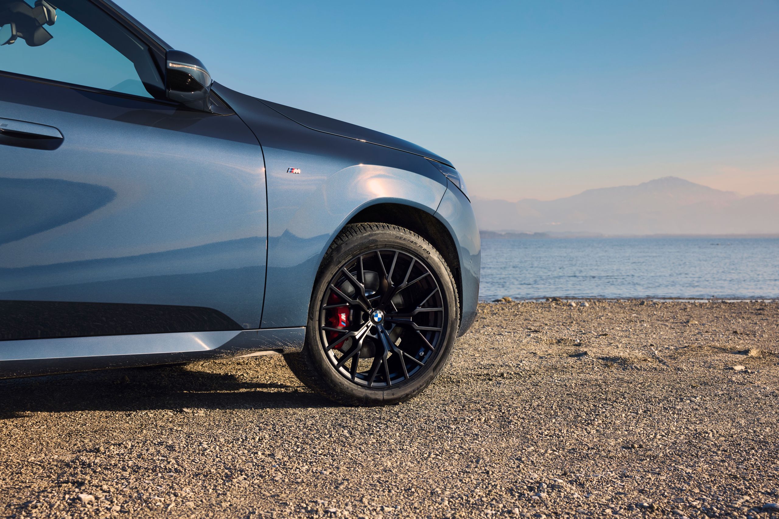 BMW stands on rocky beach – detailed view of wheel