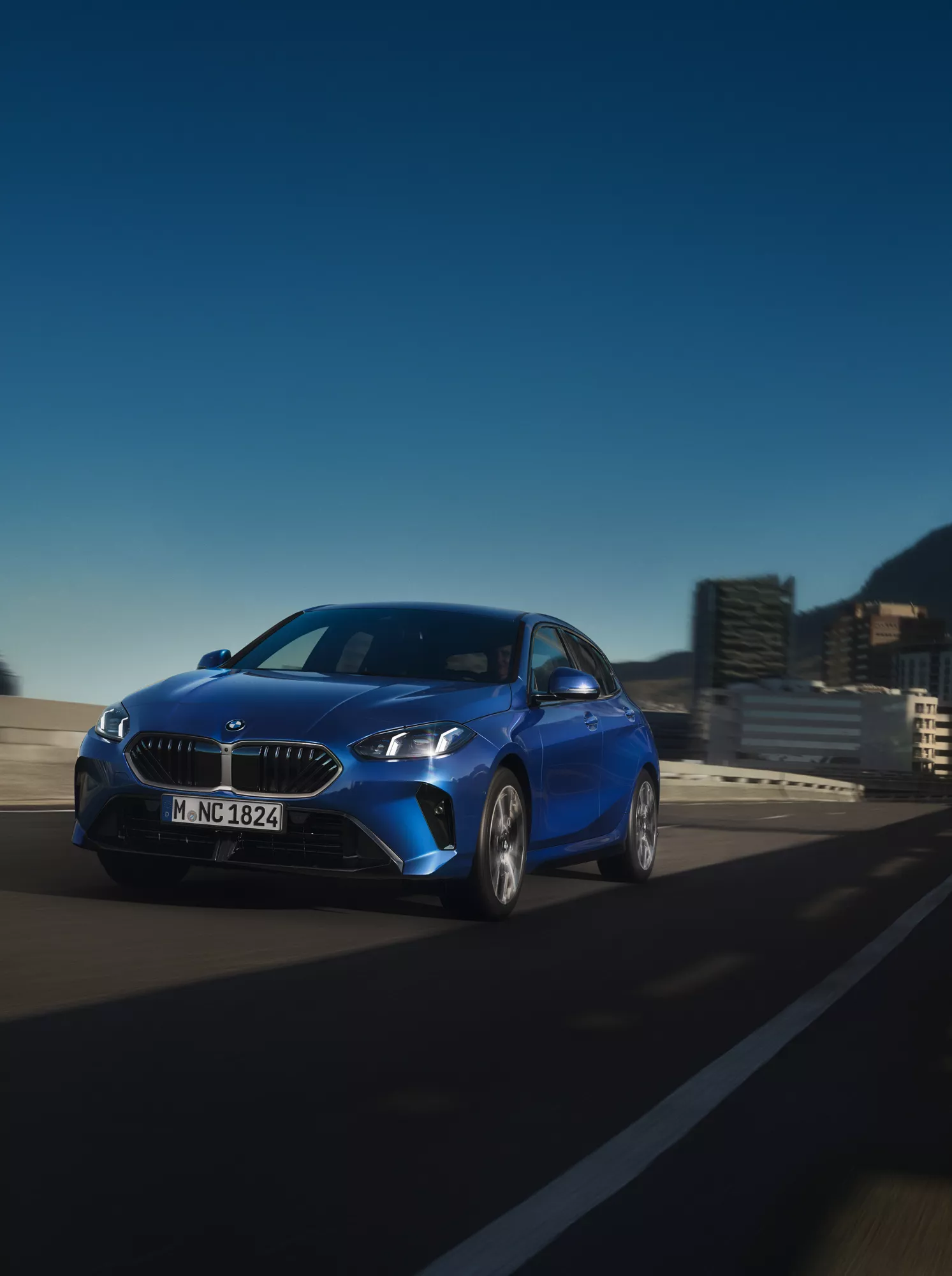Ein BMW Feuerwehrfahrzeug steht vor dem Eingang eines Rosa und Lila beleuchteten modernen Gebäudes