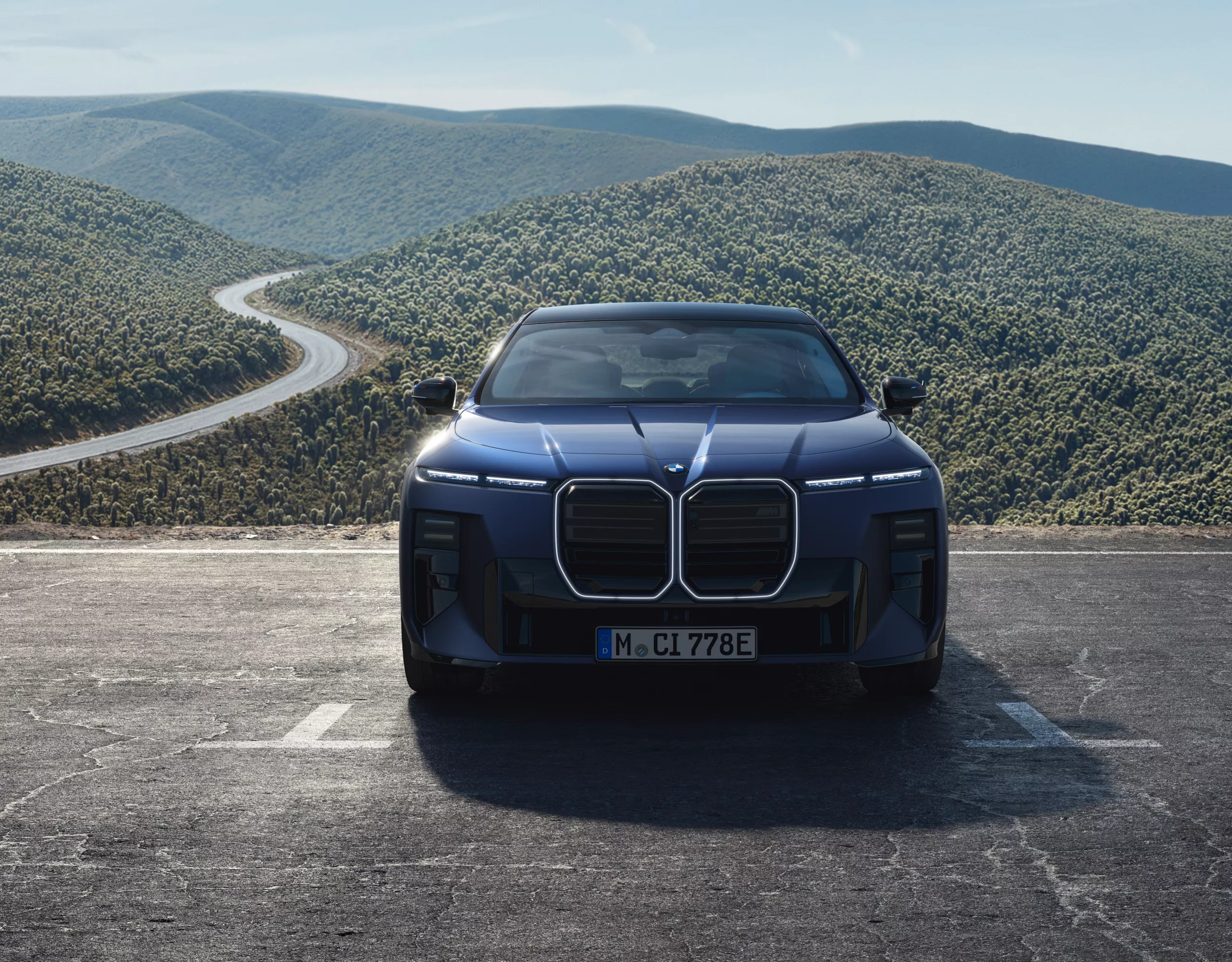 BMW M760e xDrive num parque de estacionamento, com uma paisagem montanhosa em fundo
