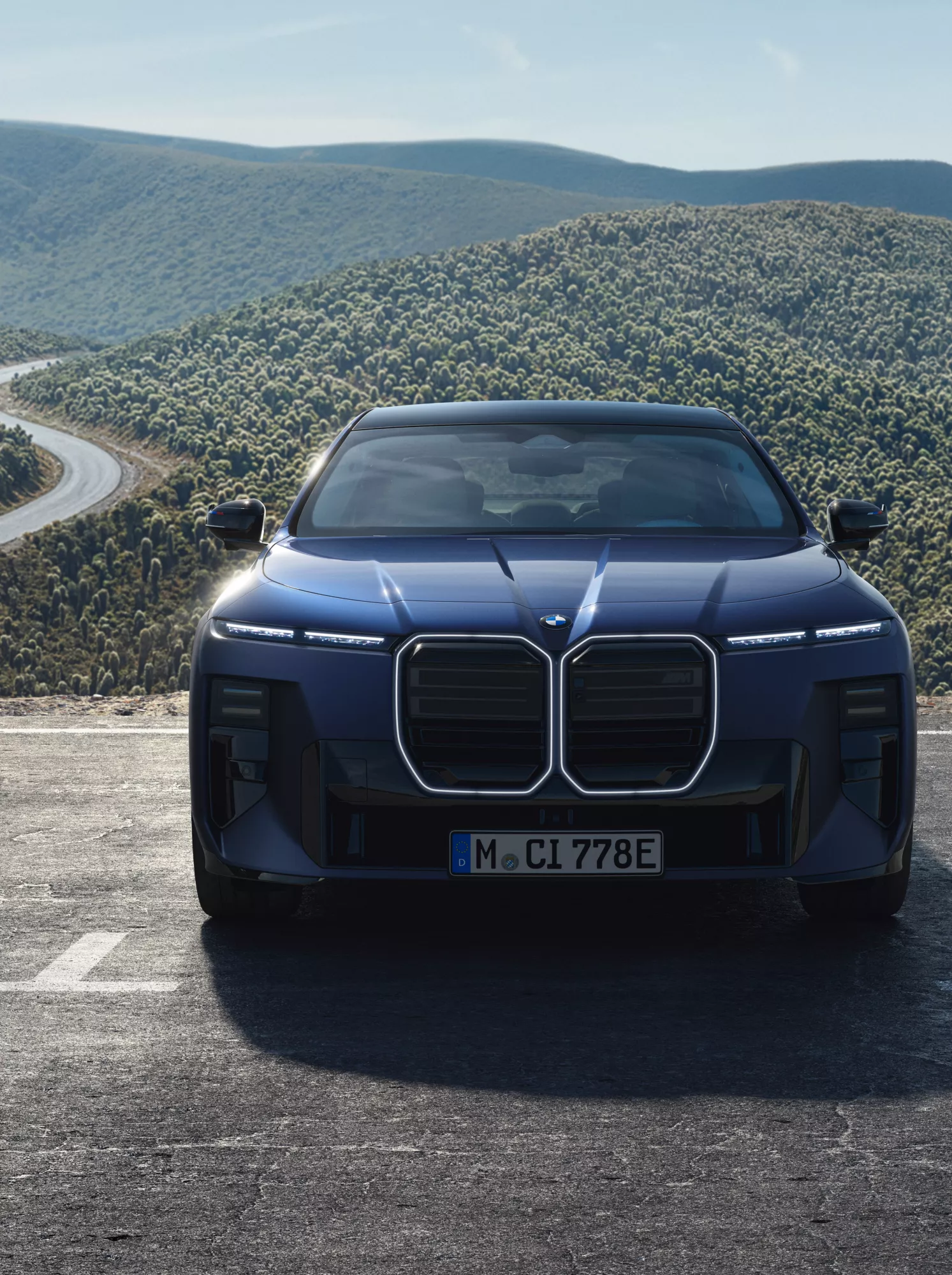 BMW M760e xDrive in a car park with a hilly landscape in the background