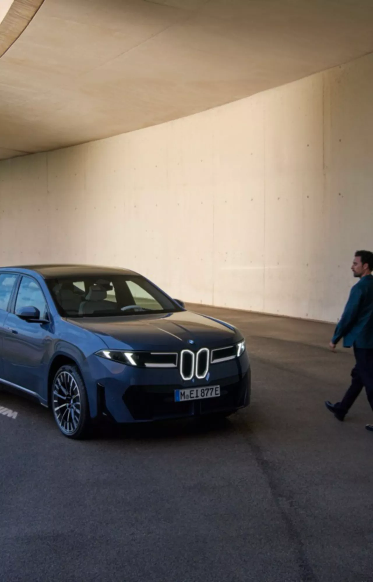 Homem a andar em direção ao BMW iX3 estacionado