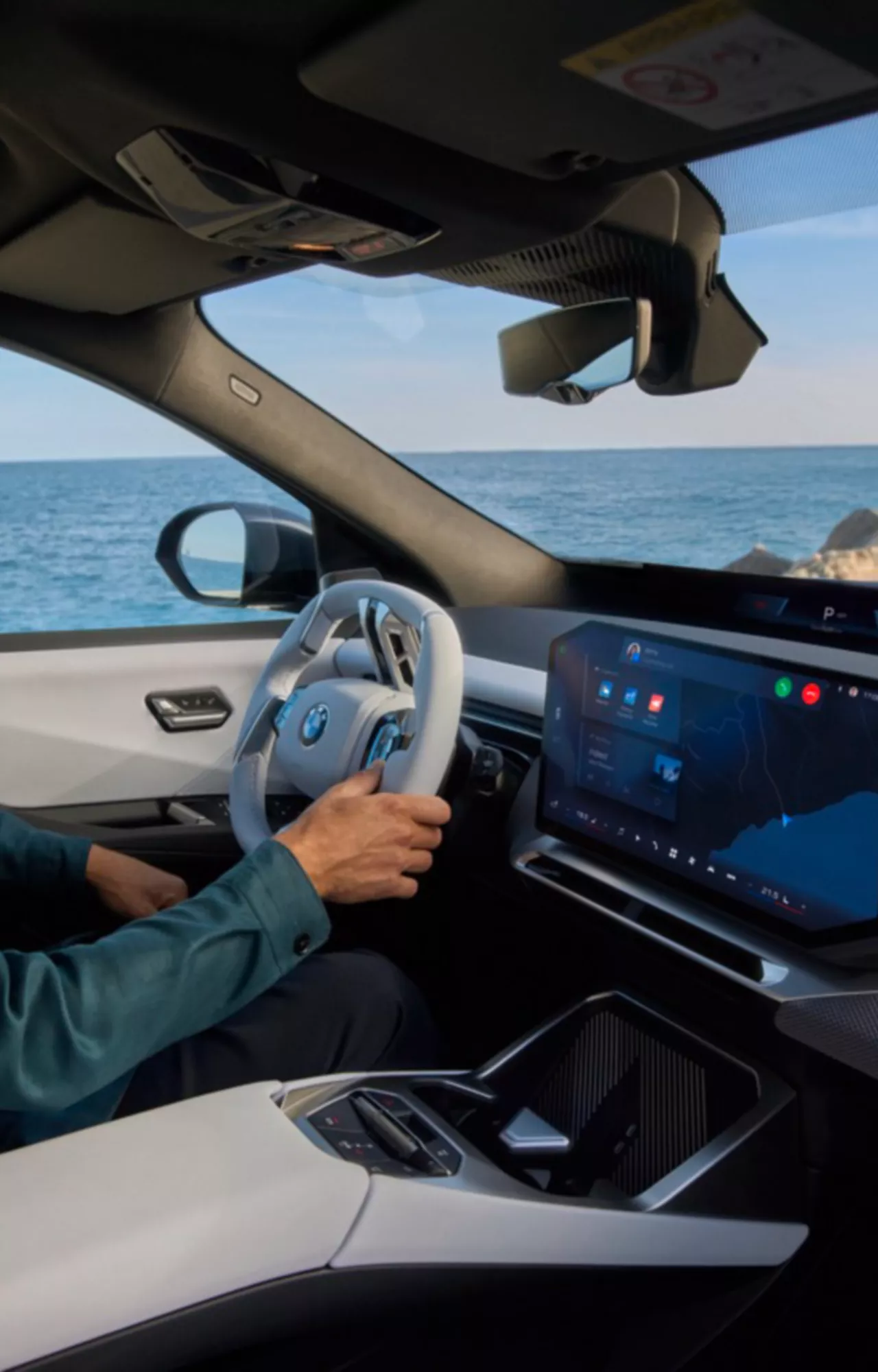Homem dentro do BMW iX3 a olhar para o Panoramic iDrive