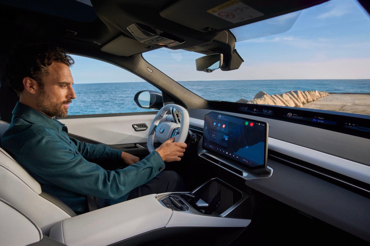 Homem dentro do BMW iX3 a olhar para o Panoramic iDrive
