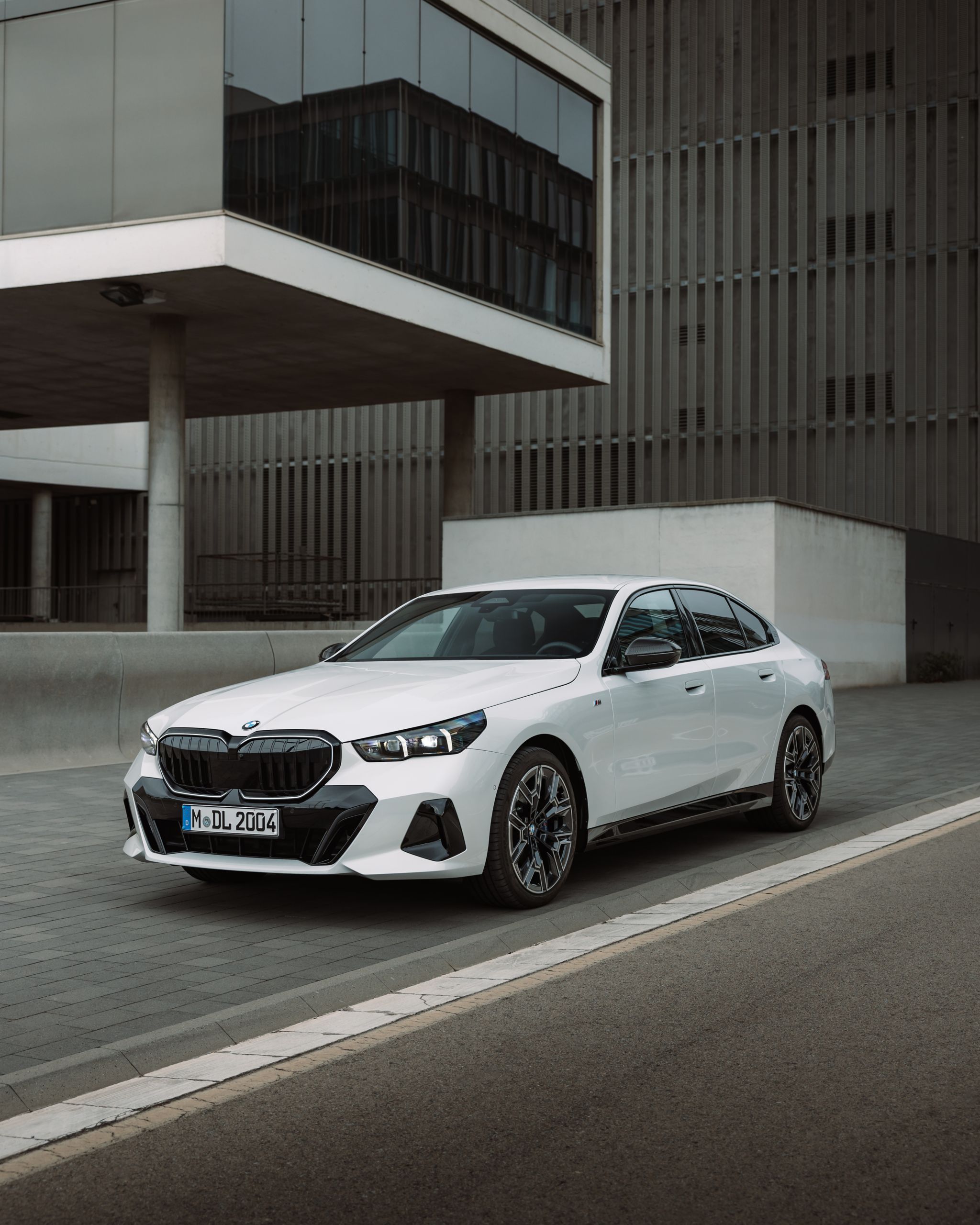 A BMW drives along a road