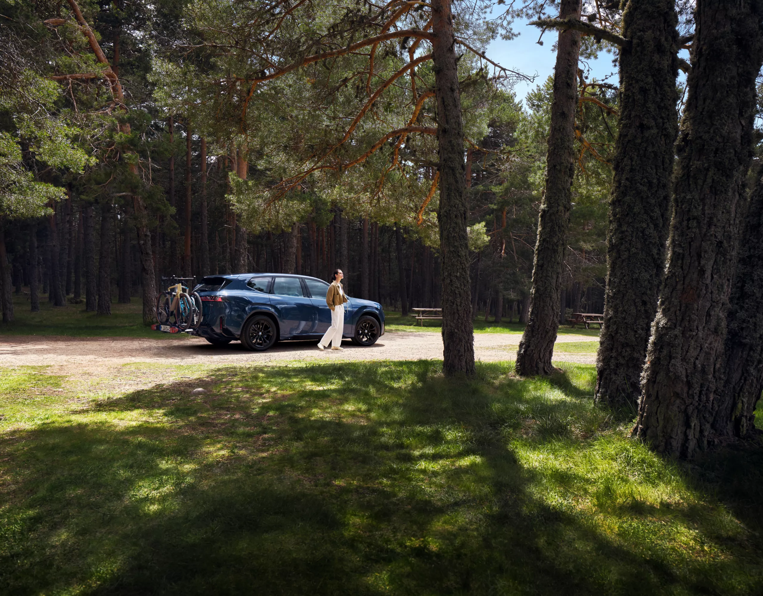 Une BMW avec deux vélos montés sur le porte-vélos arrière est stationnée dans une rue