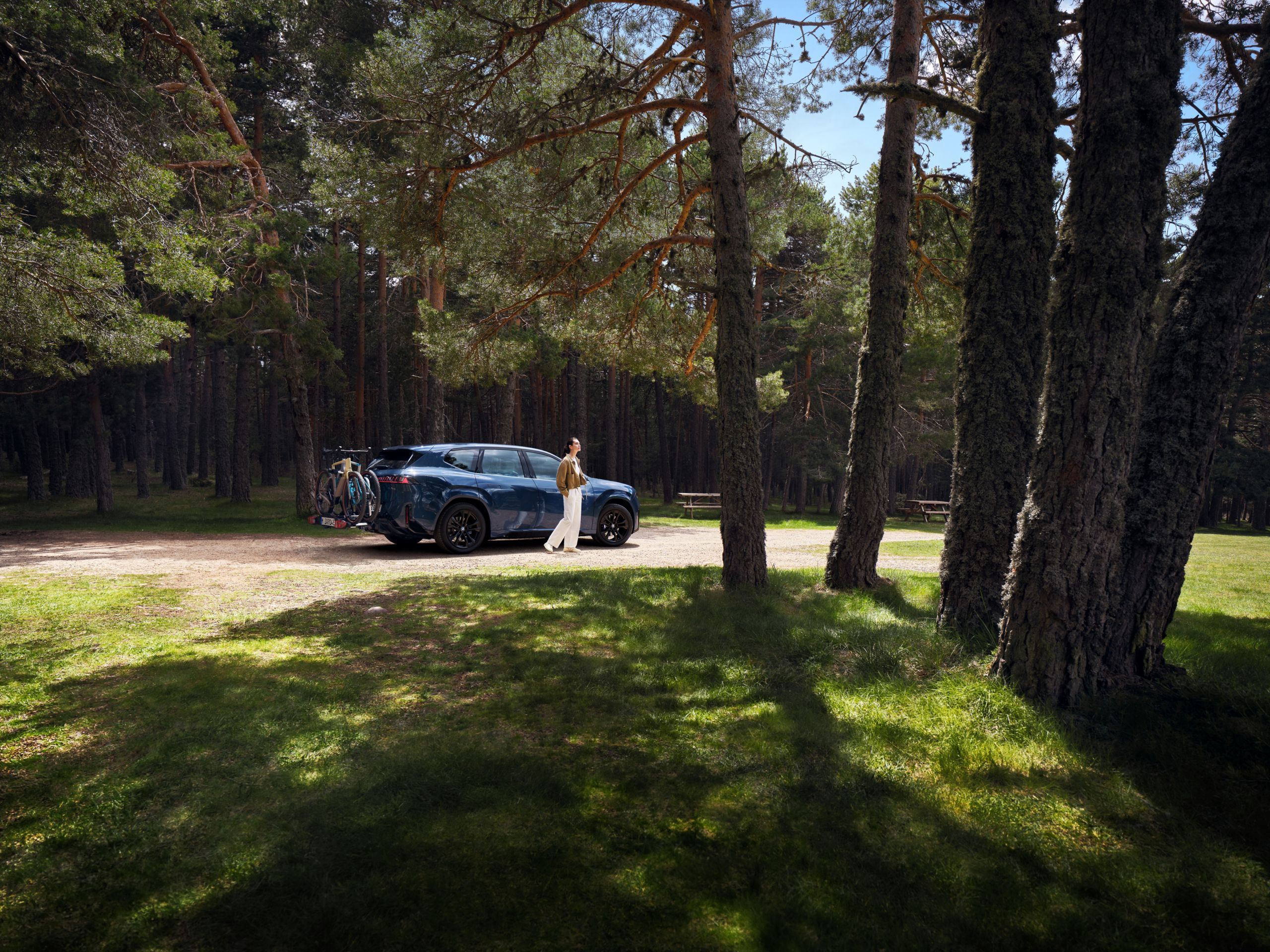 Une BMW avec deux vélos montés sur le porte-vélos arrière est stationnée dans une rue