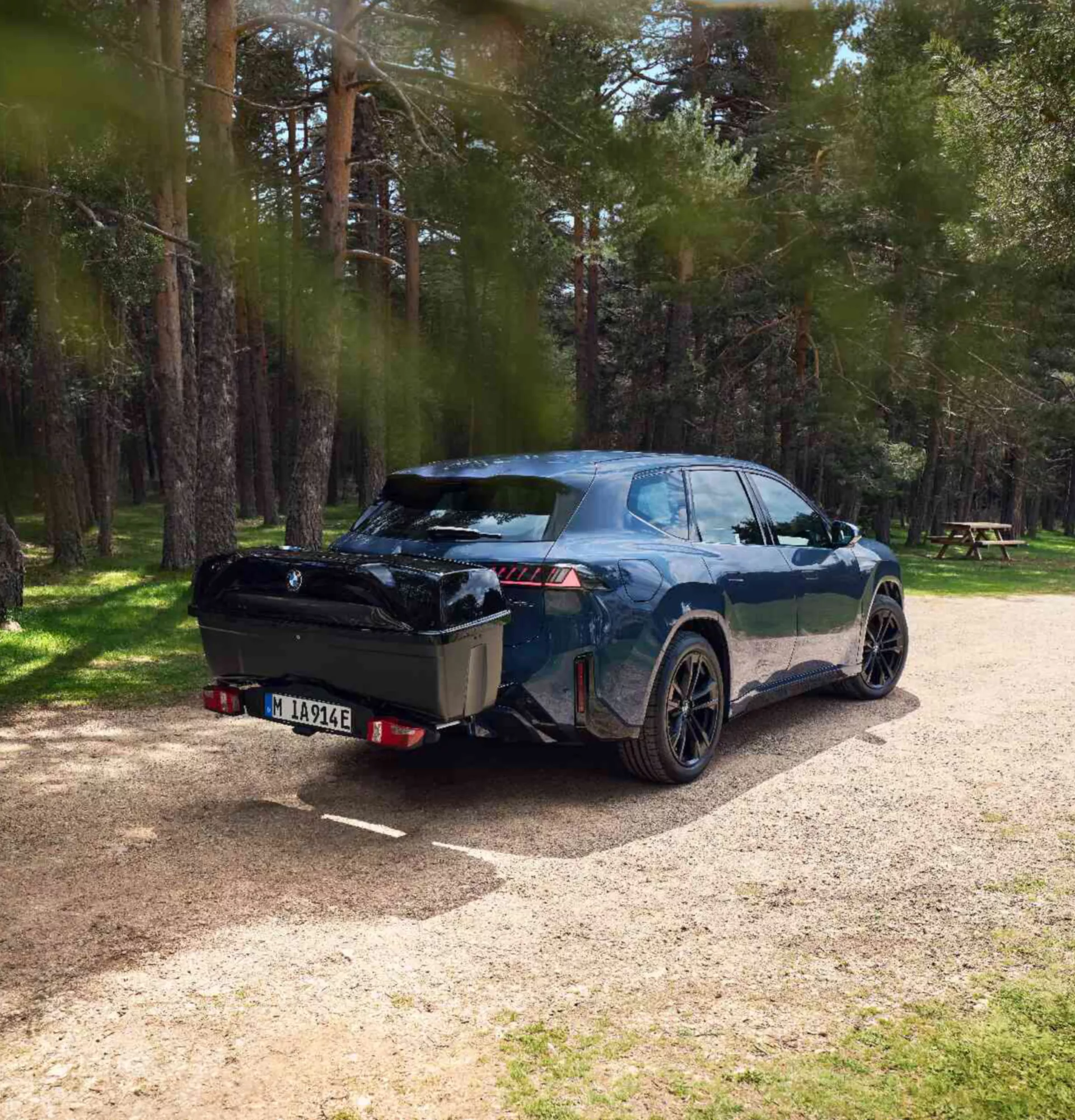 Person belädt die am BMW montierte Heckbox