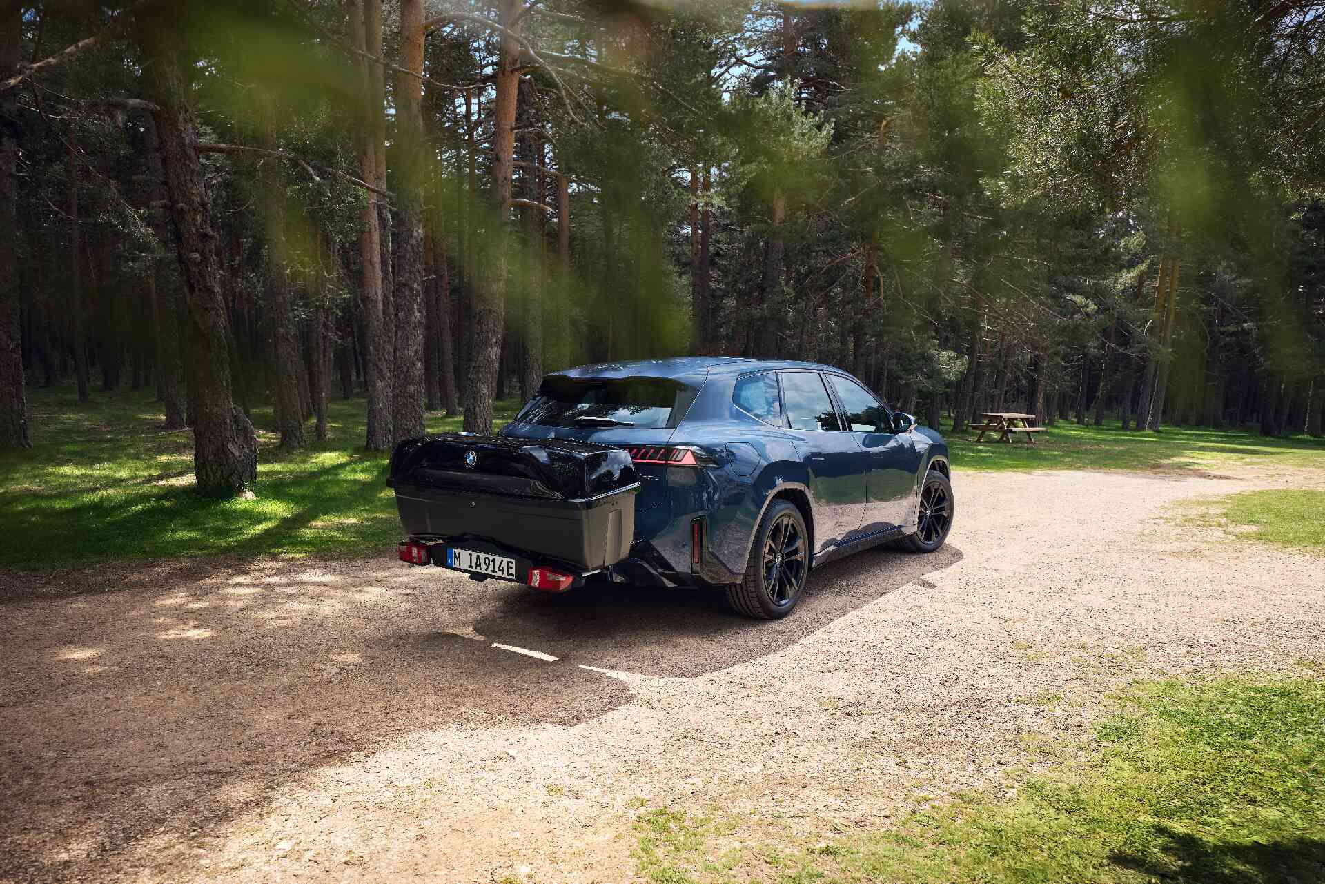 Person belädt die am BMW montierte Heckbox