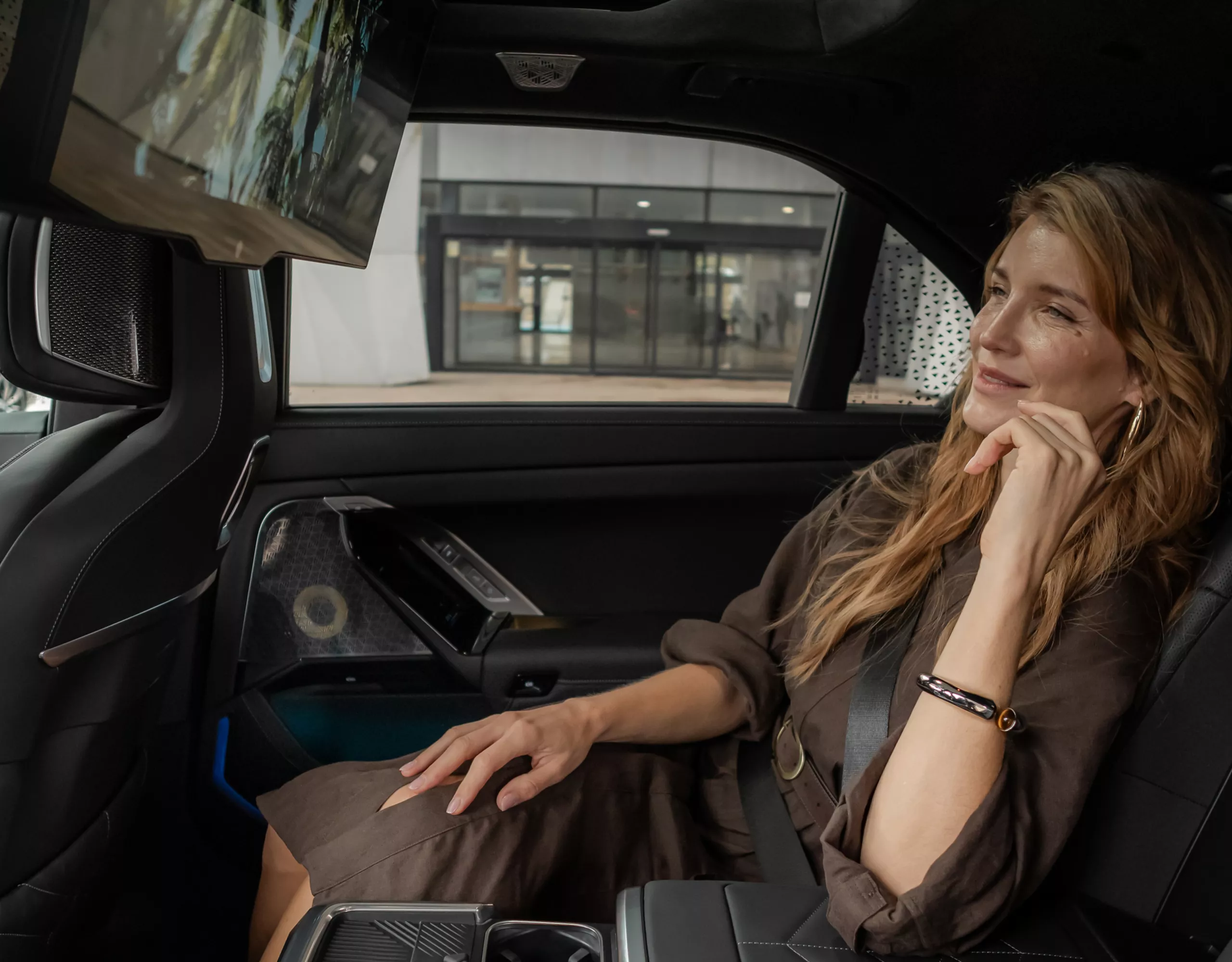 Une femme d'affaires se détend dans l'intérieur luxueux d'une BMW et profite du confort du siège arrière spacieux et de l'équipement haut de gamme