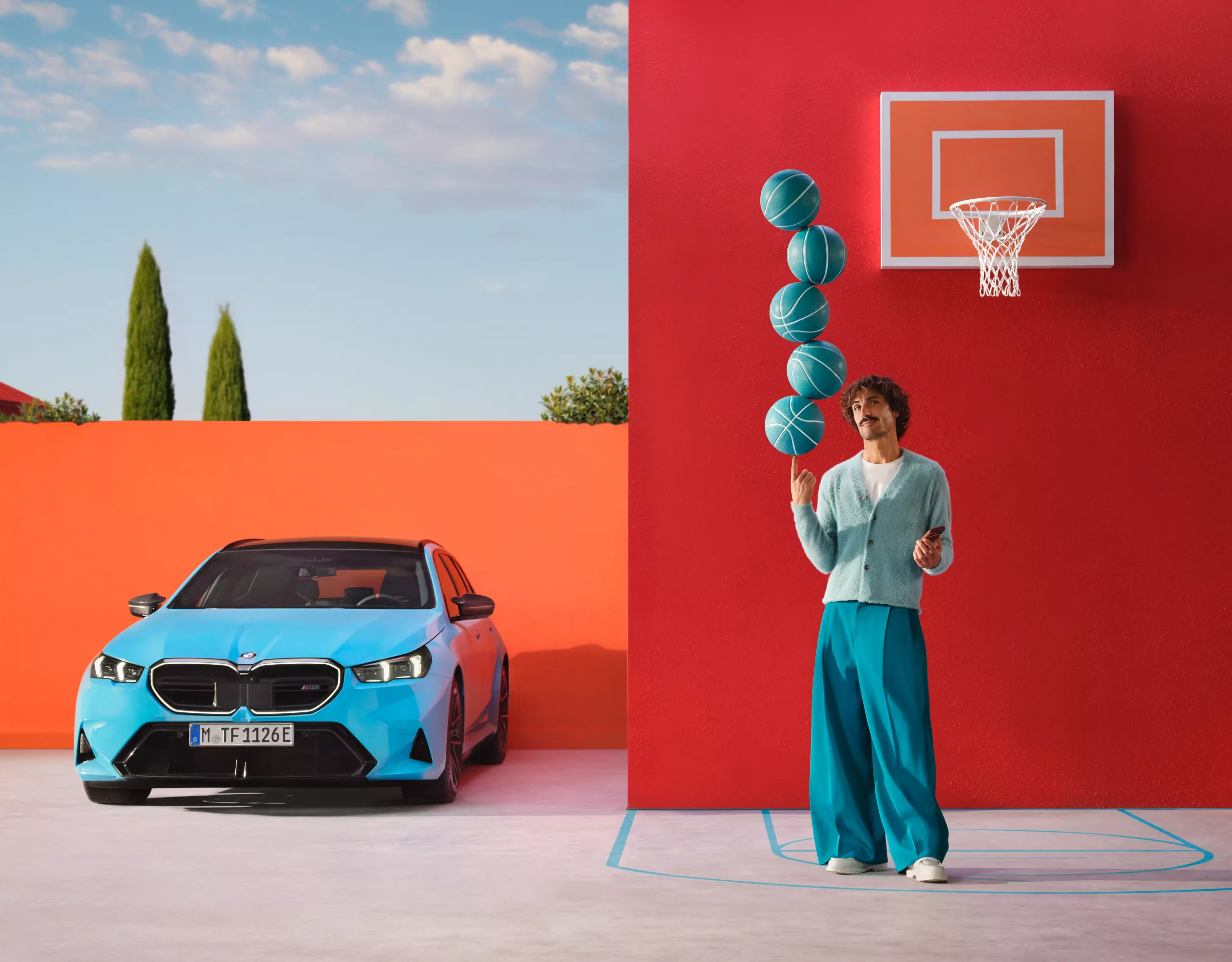 Hombre sujetando pelotas de baloncesto sin que se le caigan