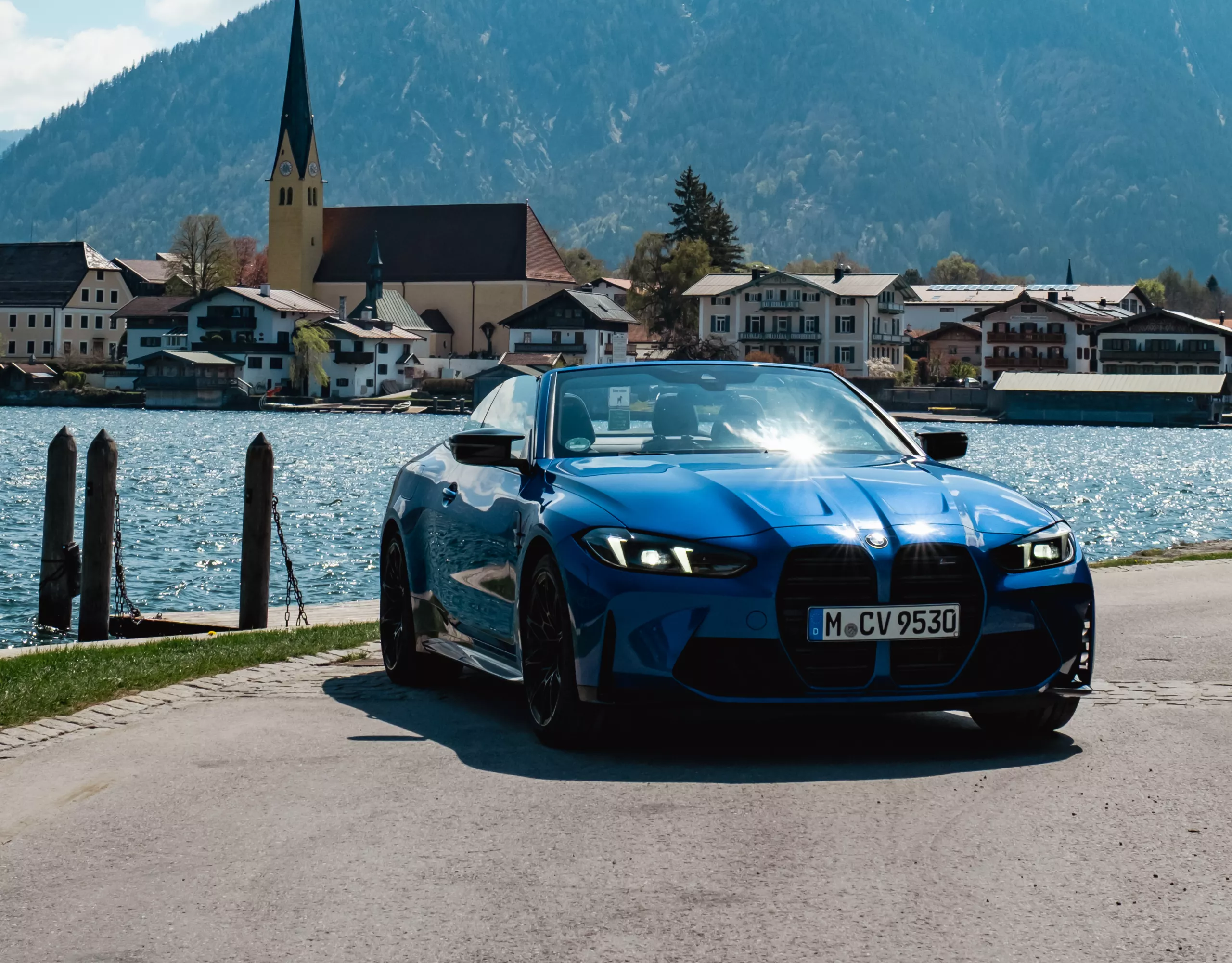 BMW M4 Cabrio am Tegernsee mit Bergpanorama im Hintergrund.