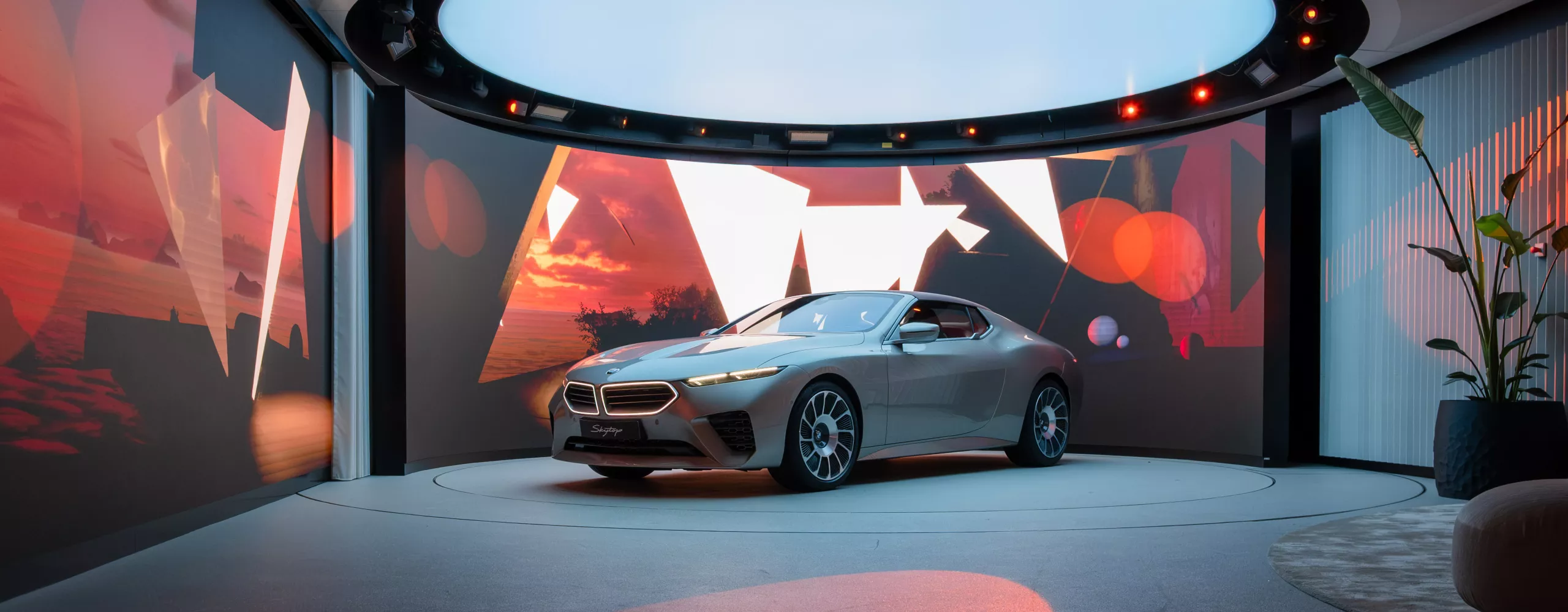 BMW Skytop concept vehicle displayed on a stage with a dynamic light and media installation.