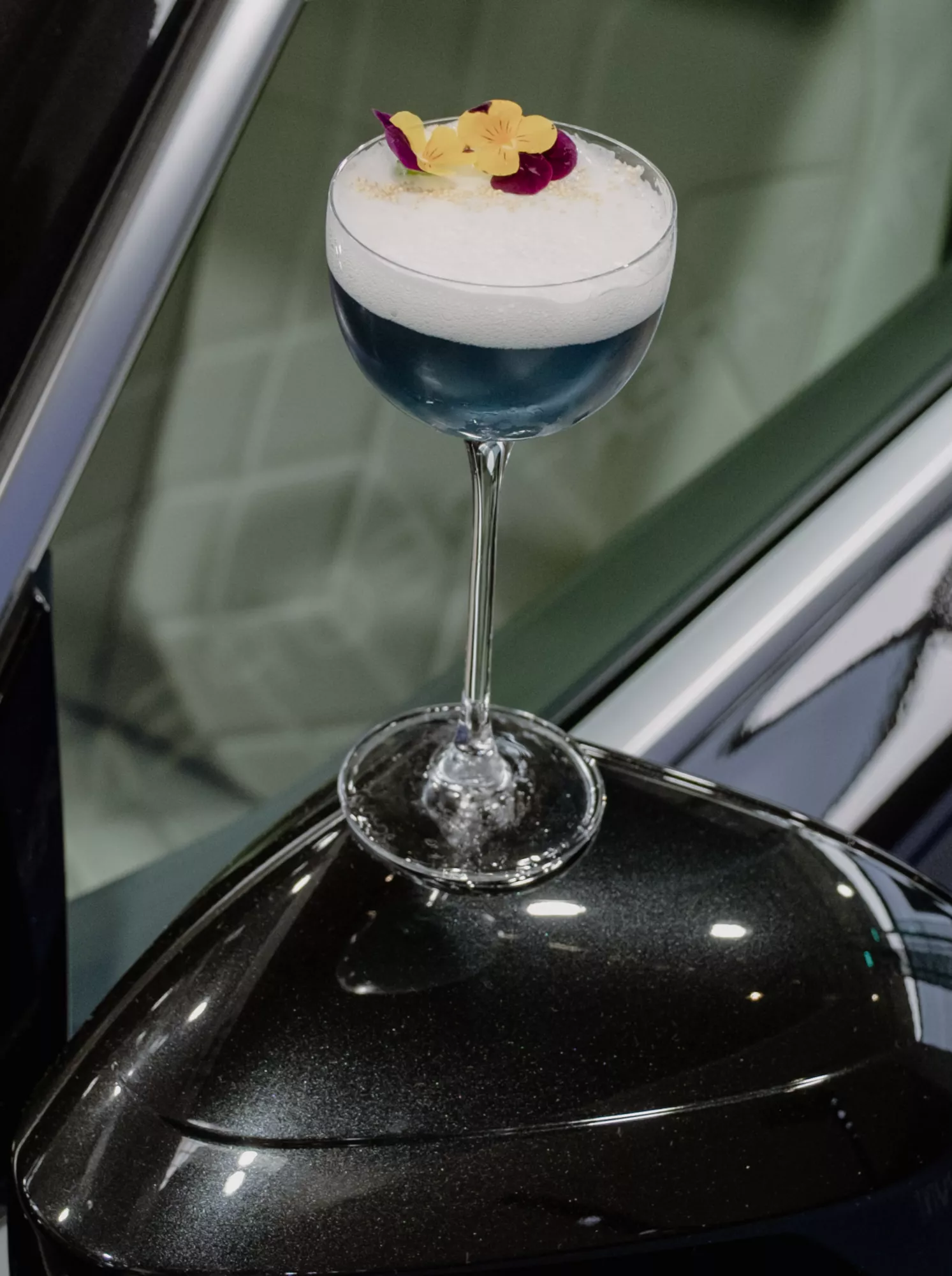 Blauer Signature-Cocktail auf dem Außenspiegel eines BMW 7 in der BMW Welt.