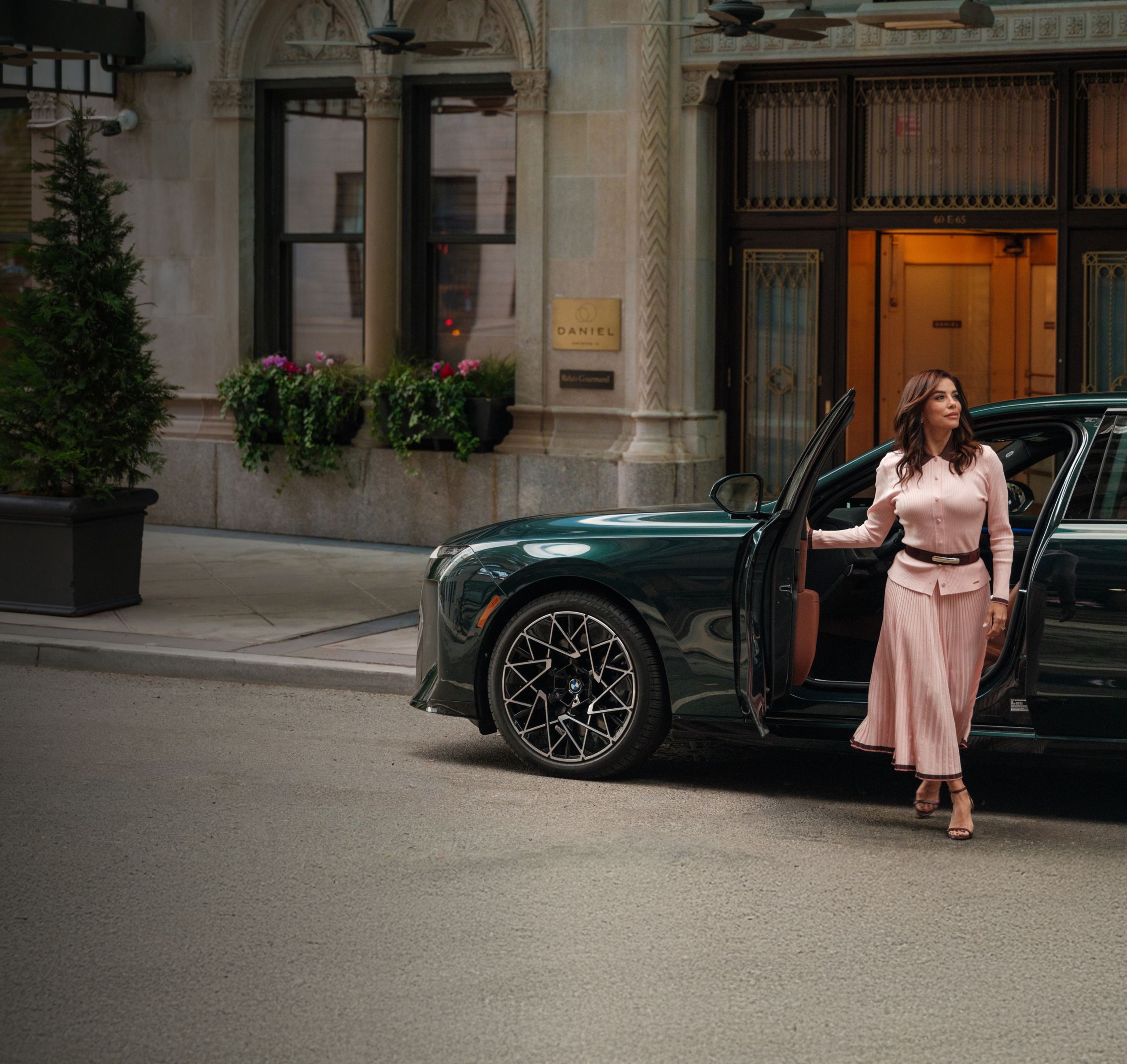 Eva Longoria emerges from a dark green BMW 7 Series Sedan parked on a city street