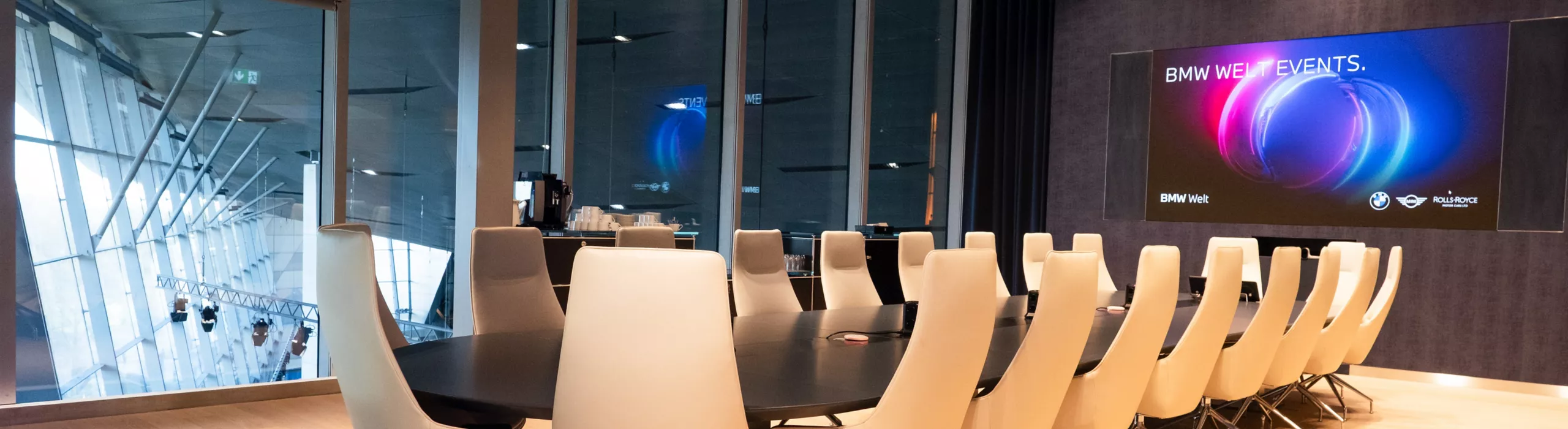 Conference room with large table and seating in the Business Club with a view over BMW Welt