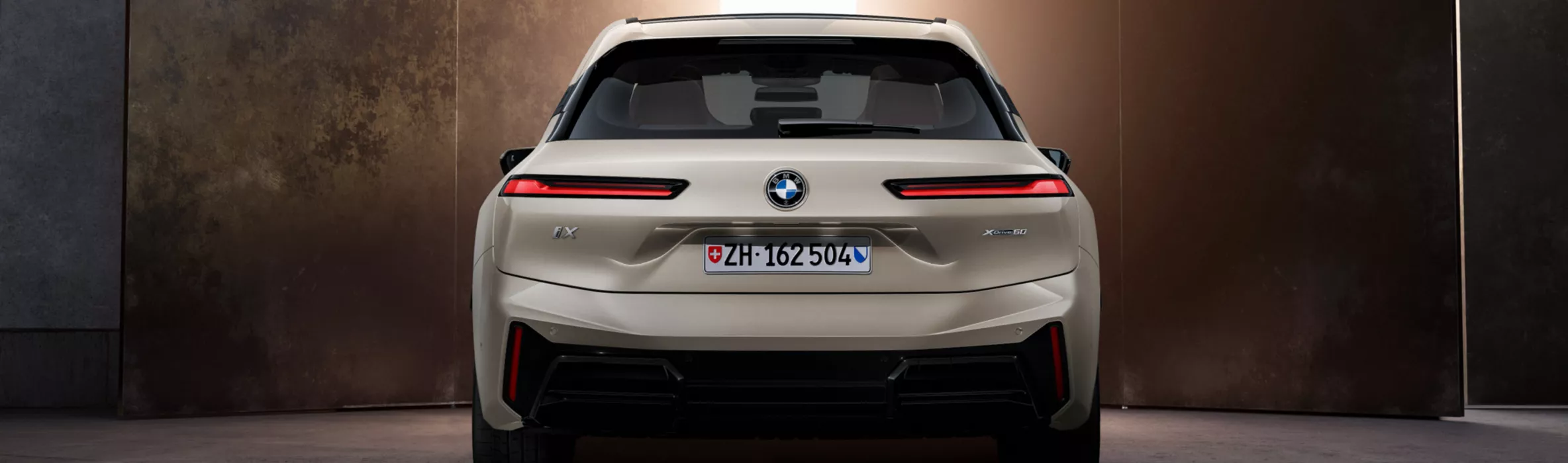 Mujinga Kambundji lehnt an BMW i5 M Brooklyn Grau metallic im Studio.